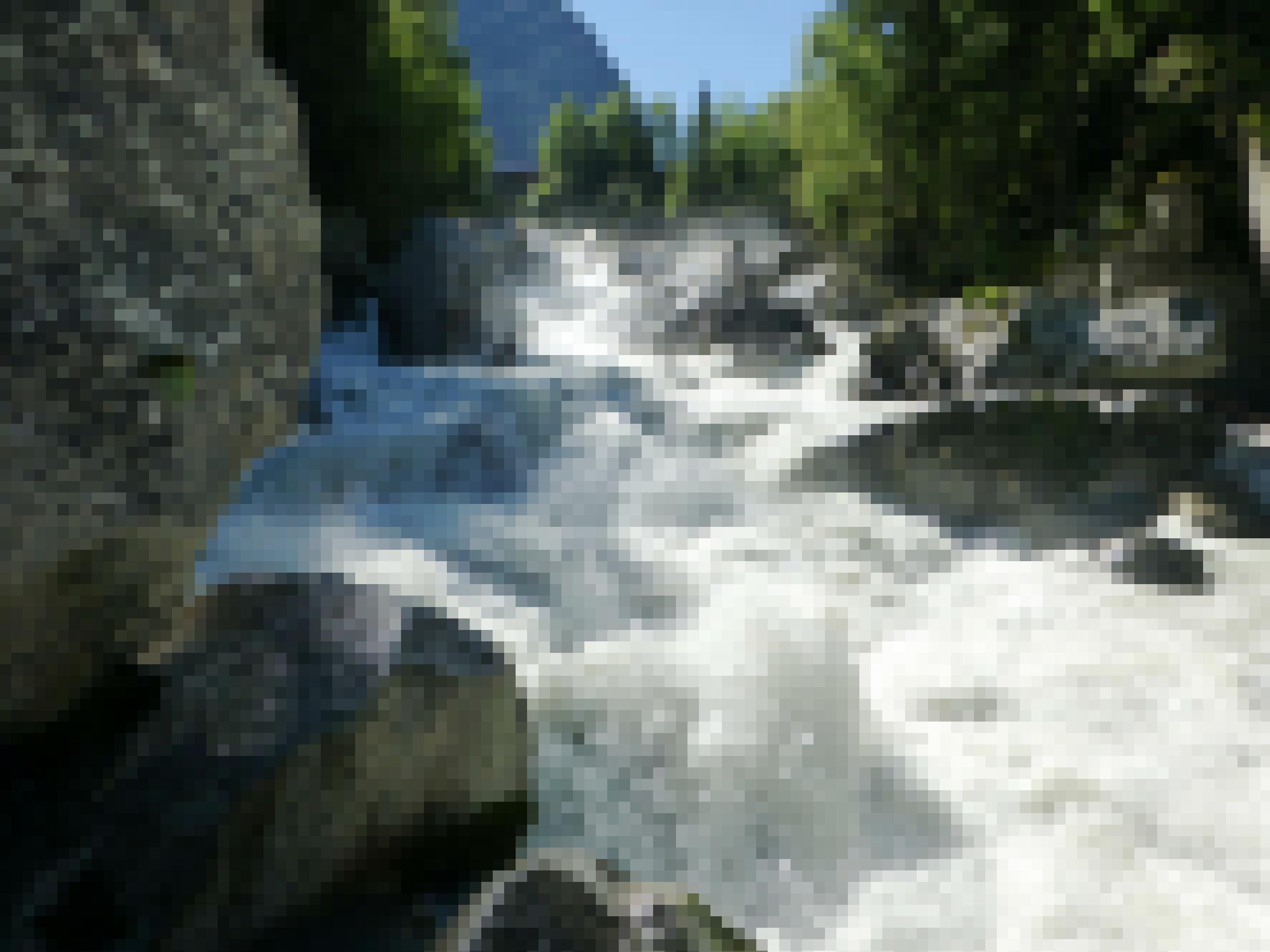 Tosender Gletscherbach mit großen Steinen und weißem Wasser.