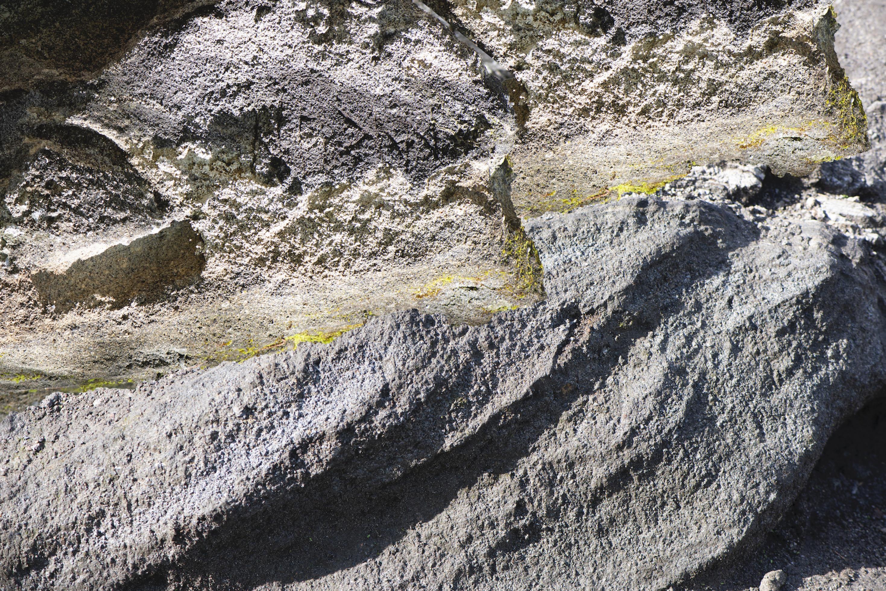 Die Fotografie zeigt eine nackte Bergwandin Nahaufnahme, in der ein gelber Streifen verläuft.