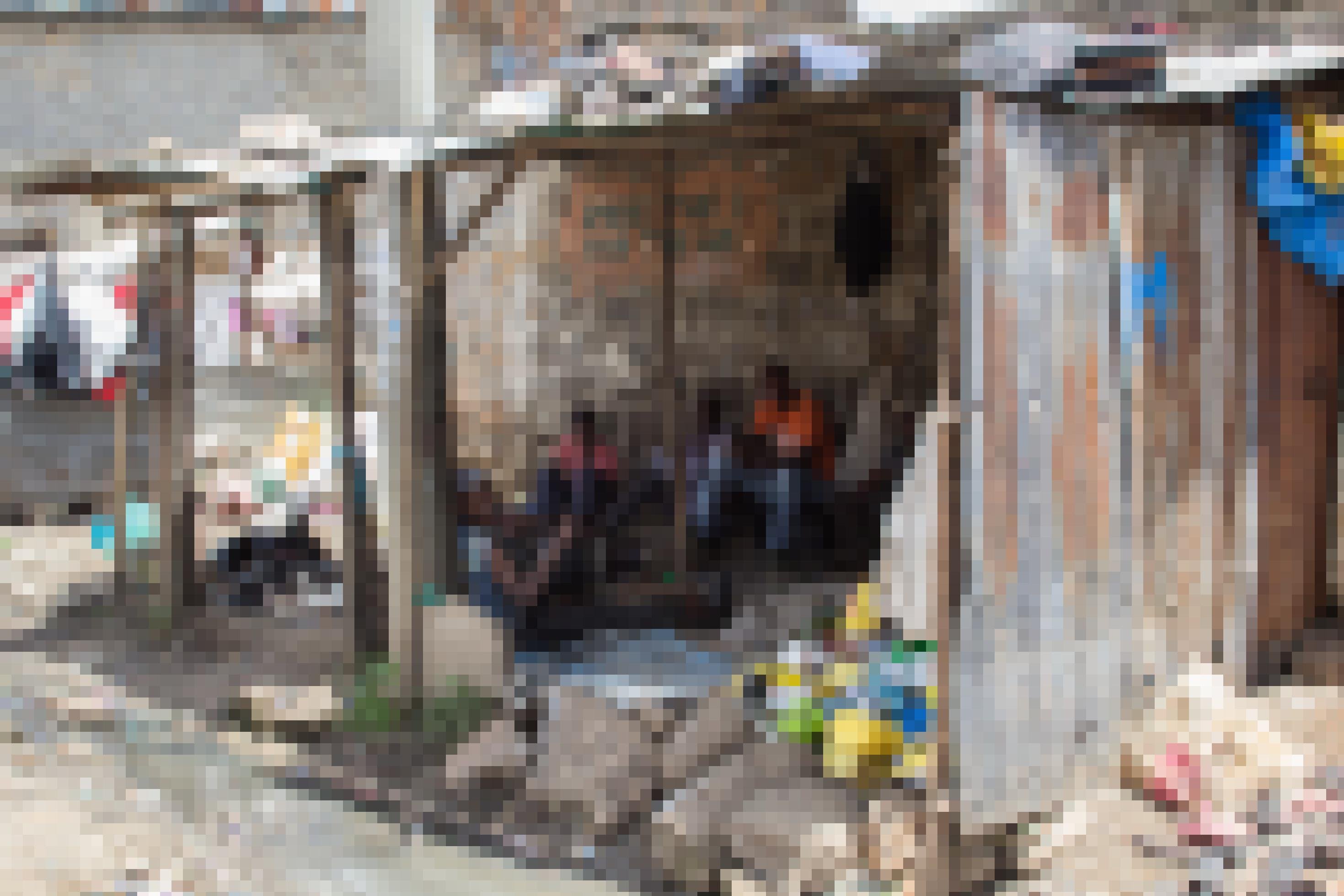 Im Slum Mathare sind Wellblech-Unterstände zu sehen, die als Verkaufsflächen dienen. Es sind keine Kunden im Bild, nur Männer, die warten – vermutlich auf Kunden.