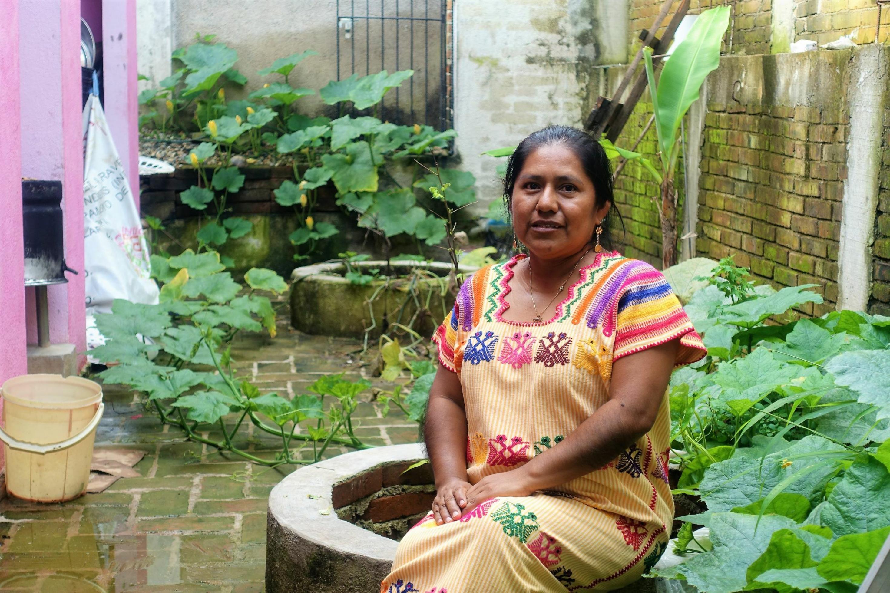 Die Kunsthandwerkerin Mónica Hernández sitzt in ihrem Garten
