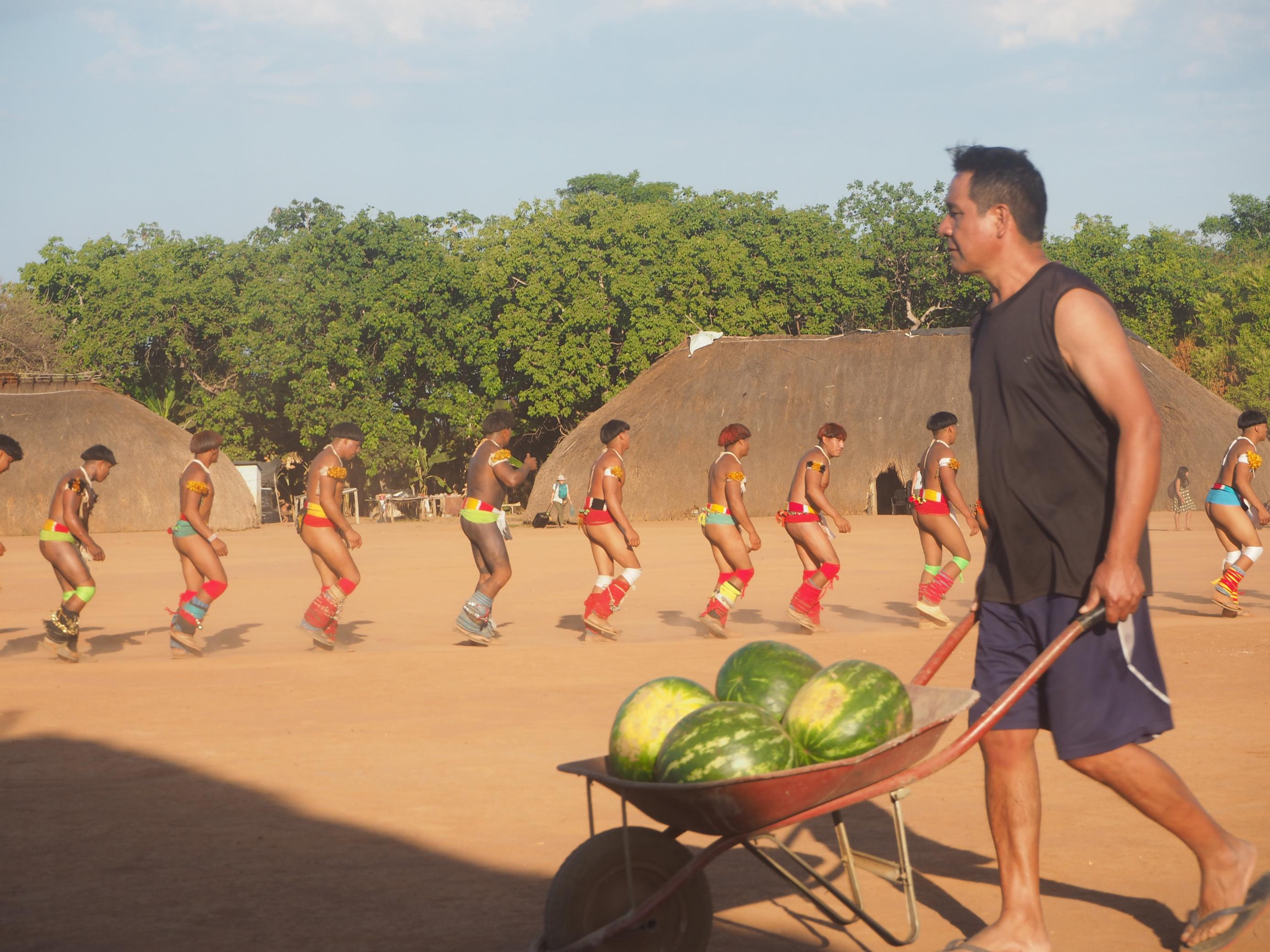 Ein Mann bringt mit einer Schubkarre mehrere Wassermelonen für die Tänzer.