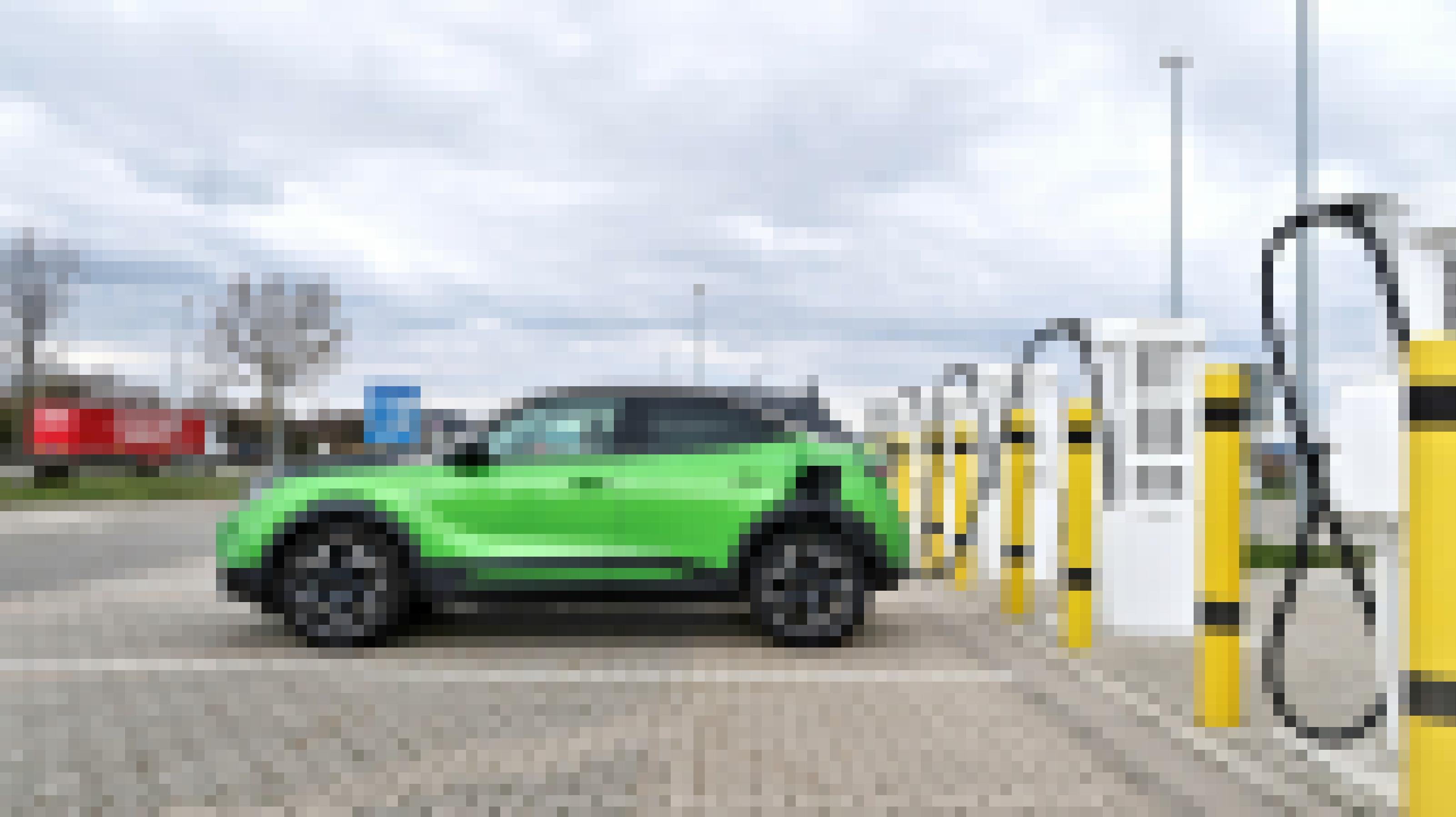 Ein grüner Opel Mokka-E lädt an einer Schnellladestation an der Autobahn auf.