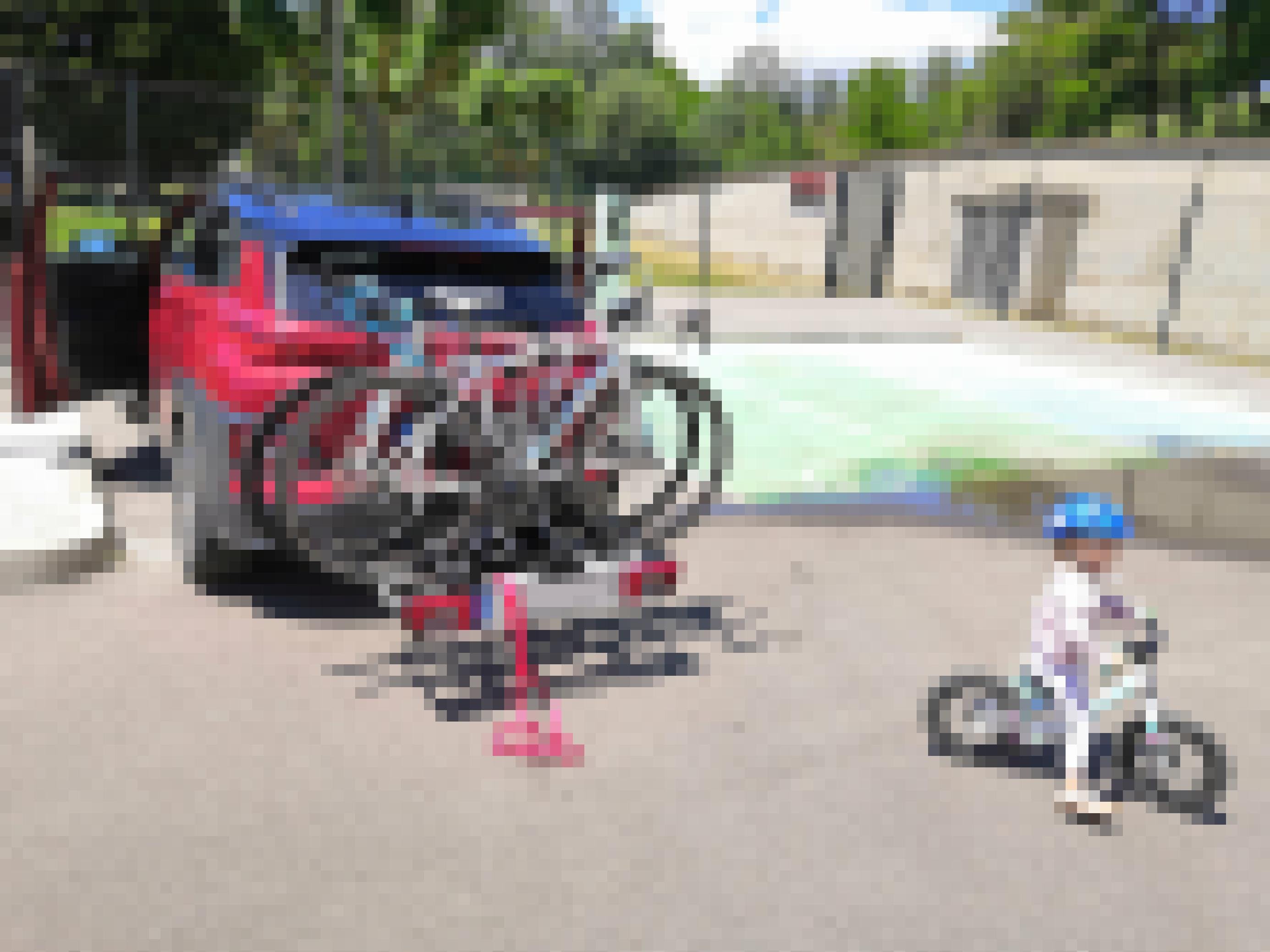 Ein Hyundai Kona tankt Strom. Im Vordergrund fährt ein kleines Mädchen mit dem Fahrrad.
