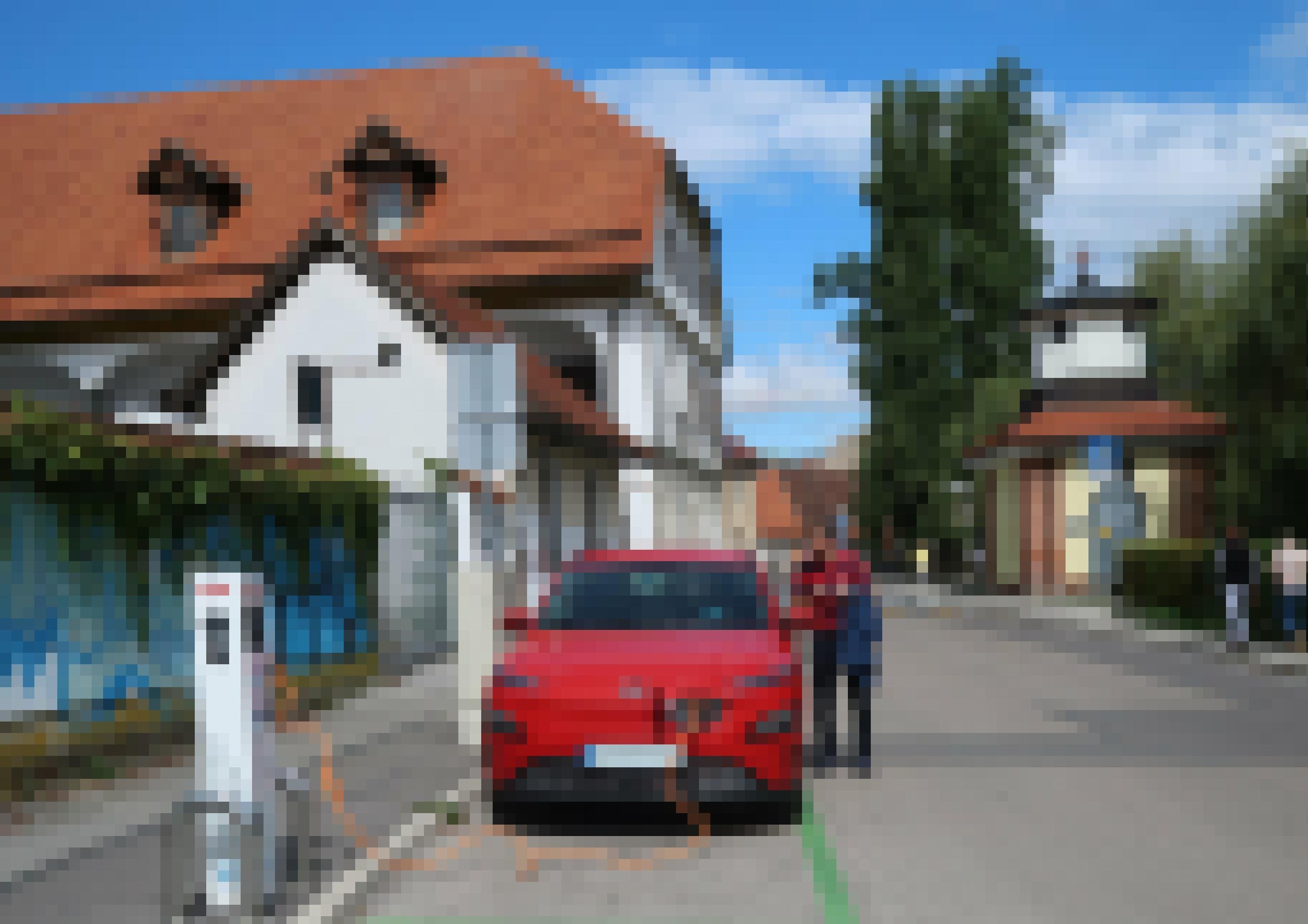 Ein rotes Elektroauto steht auf einem Parkplatz.