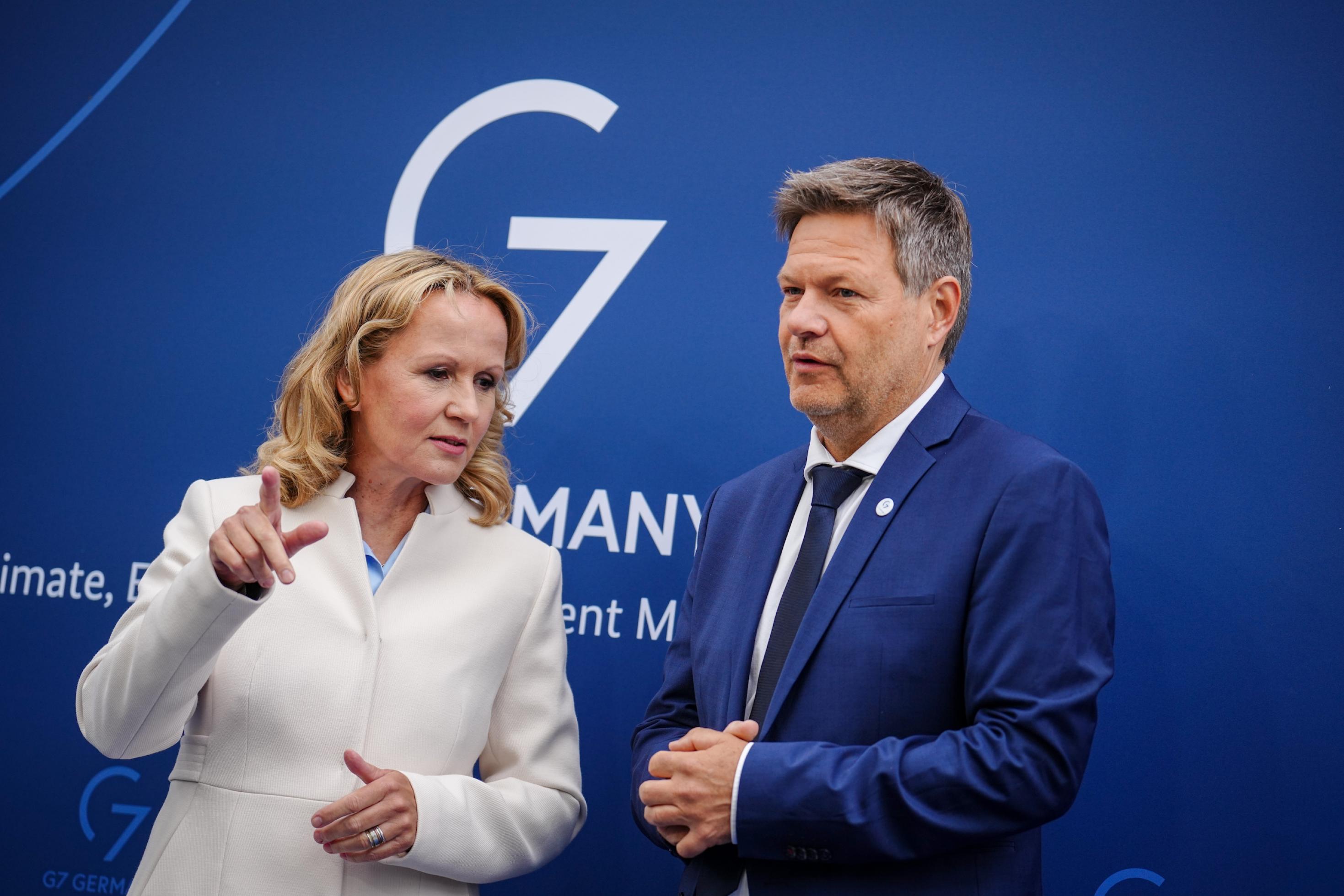 Die beiden Minister stehen nebeneinander vor einer blauen Tafel mit der Aufschrift G7.