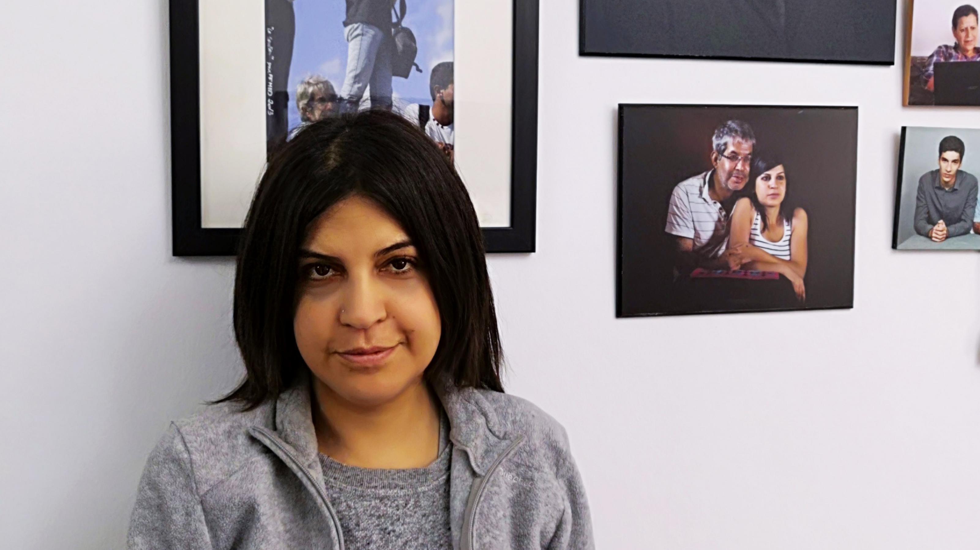 Die tunesische Aktivistin Lina Ben Mhenni vor einer Reihe von Fotos im Haus ihrer Eltern