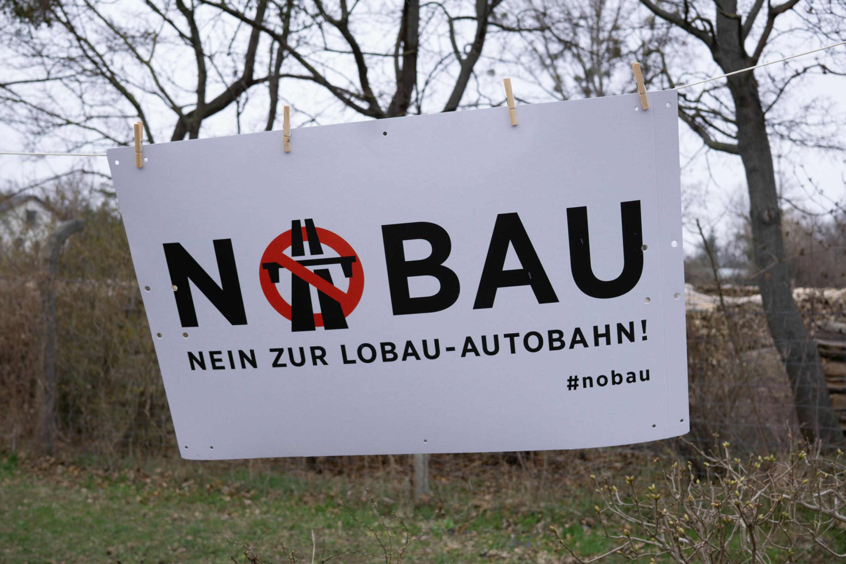 Transparent mit Aufschrift „Nobau! Nein zur Lobauautobahn“ hängt in der Lobau auf einer Leine.