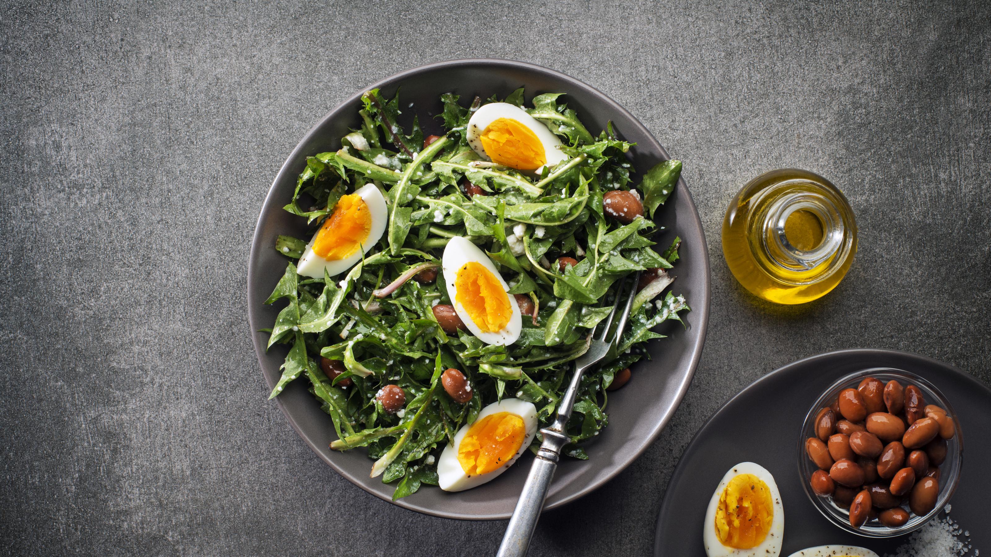 Fresh dandelion salad with eggs and beans overhead shoot