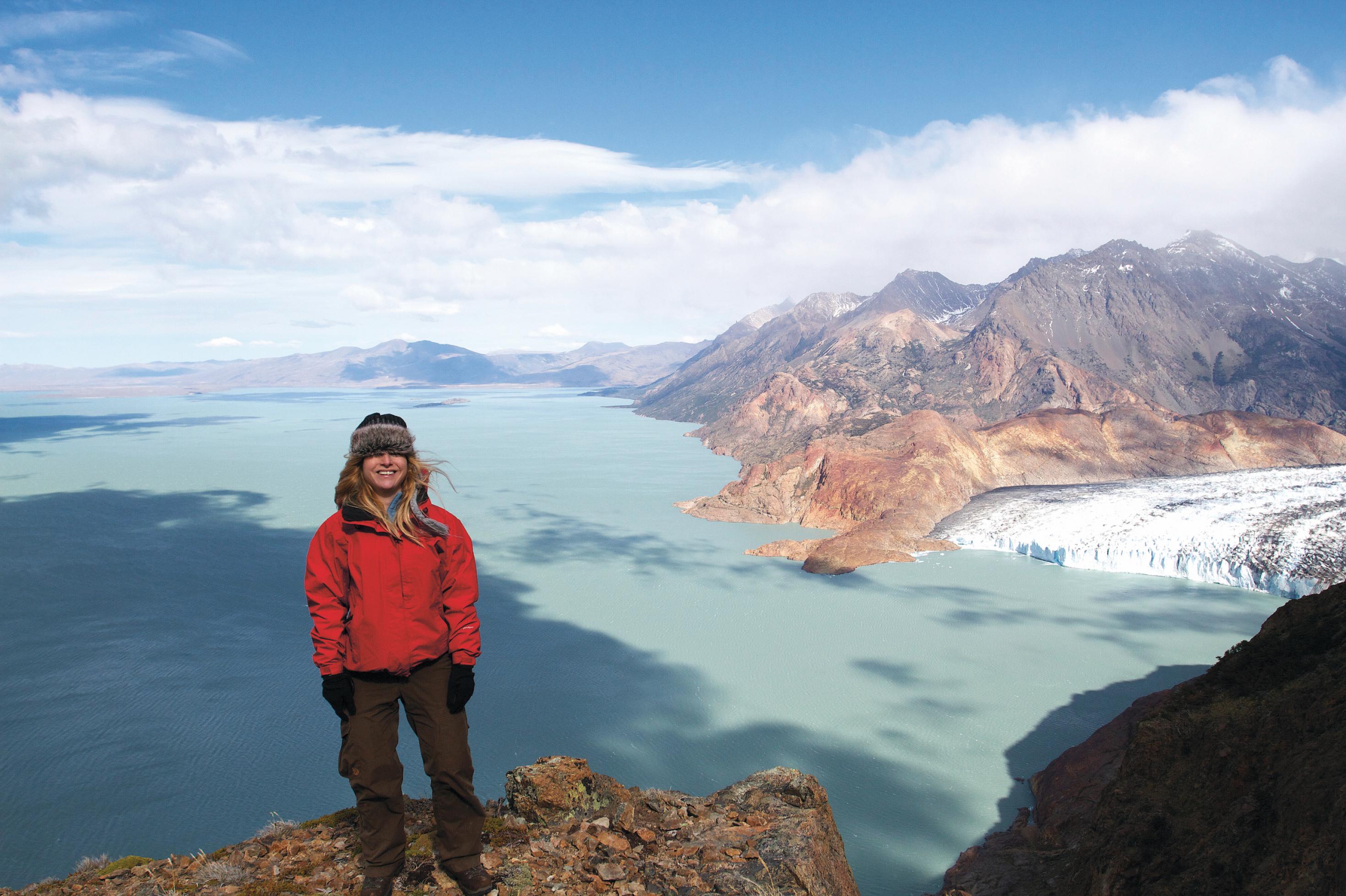 Eine Frau steht vor einer Gletscherlandschaft