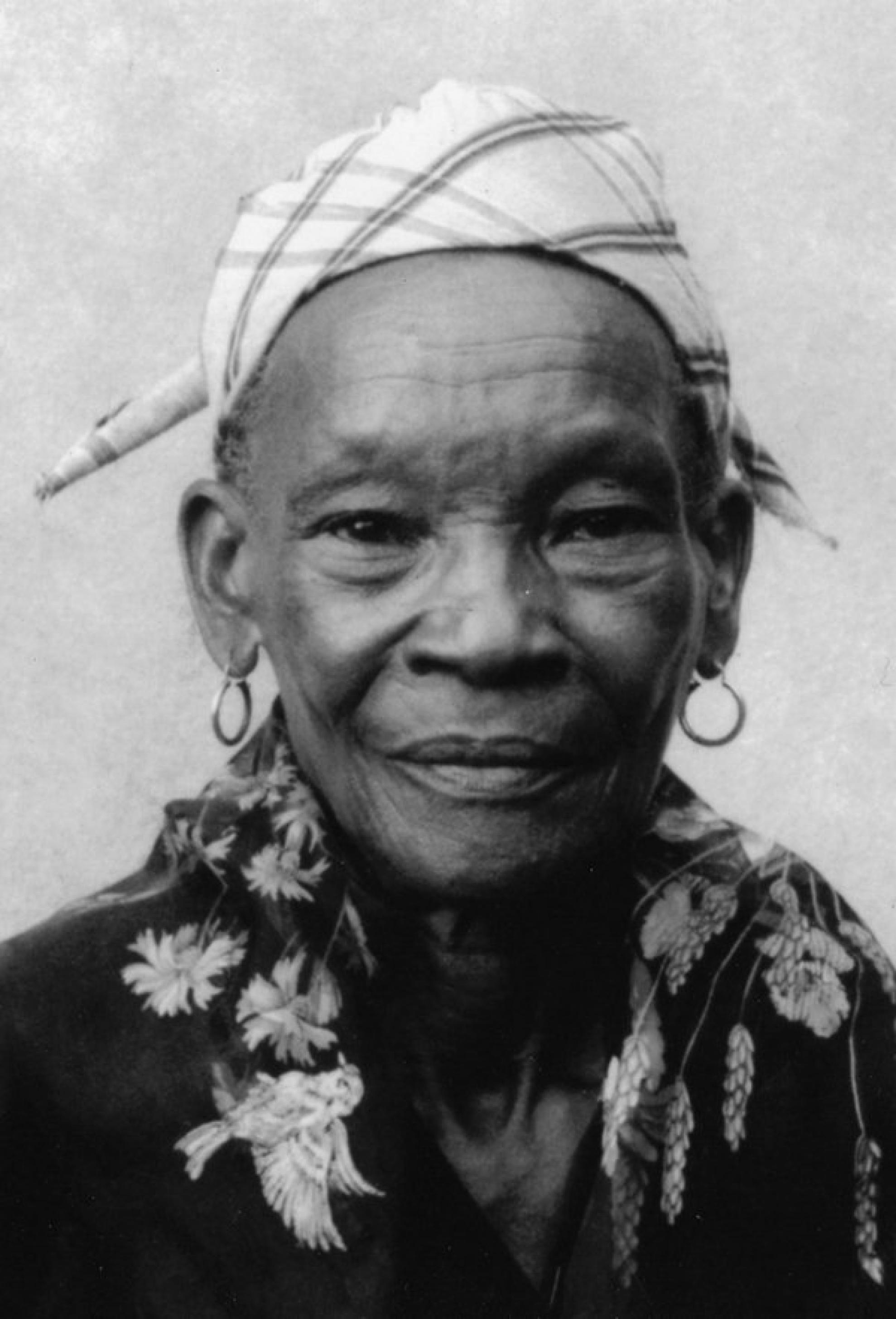 Schwarz-weiß-Portrait einer alten Frau. Sie trägt ein Kopftuch.