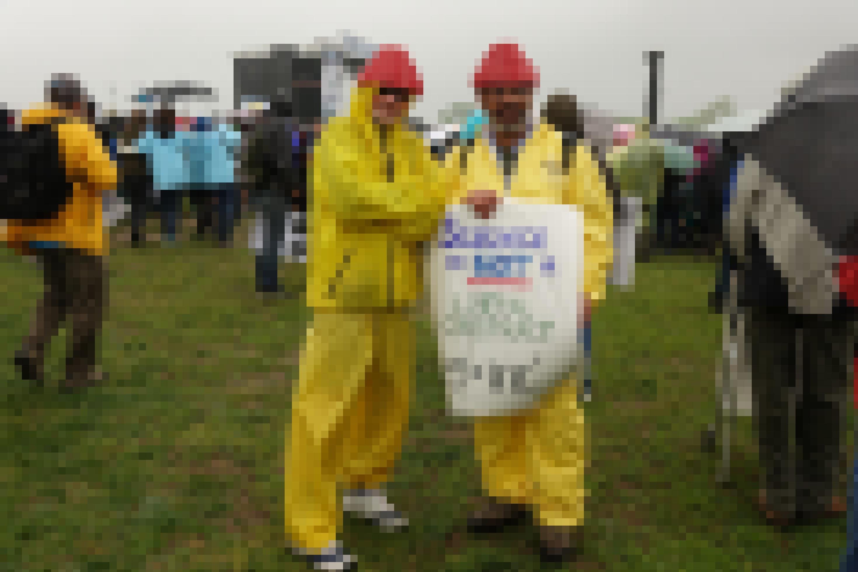 Zwei Männer sind verkleidet und halten ein Schild hoch. Darauf steht „Science is not a liberal conspiracy“ und „e = mc hoch 2“