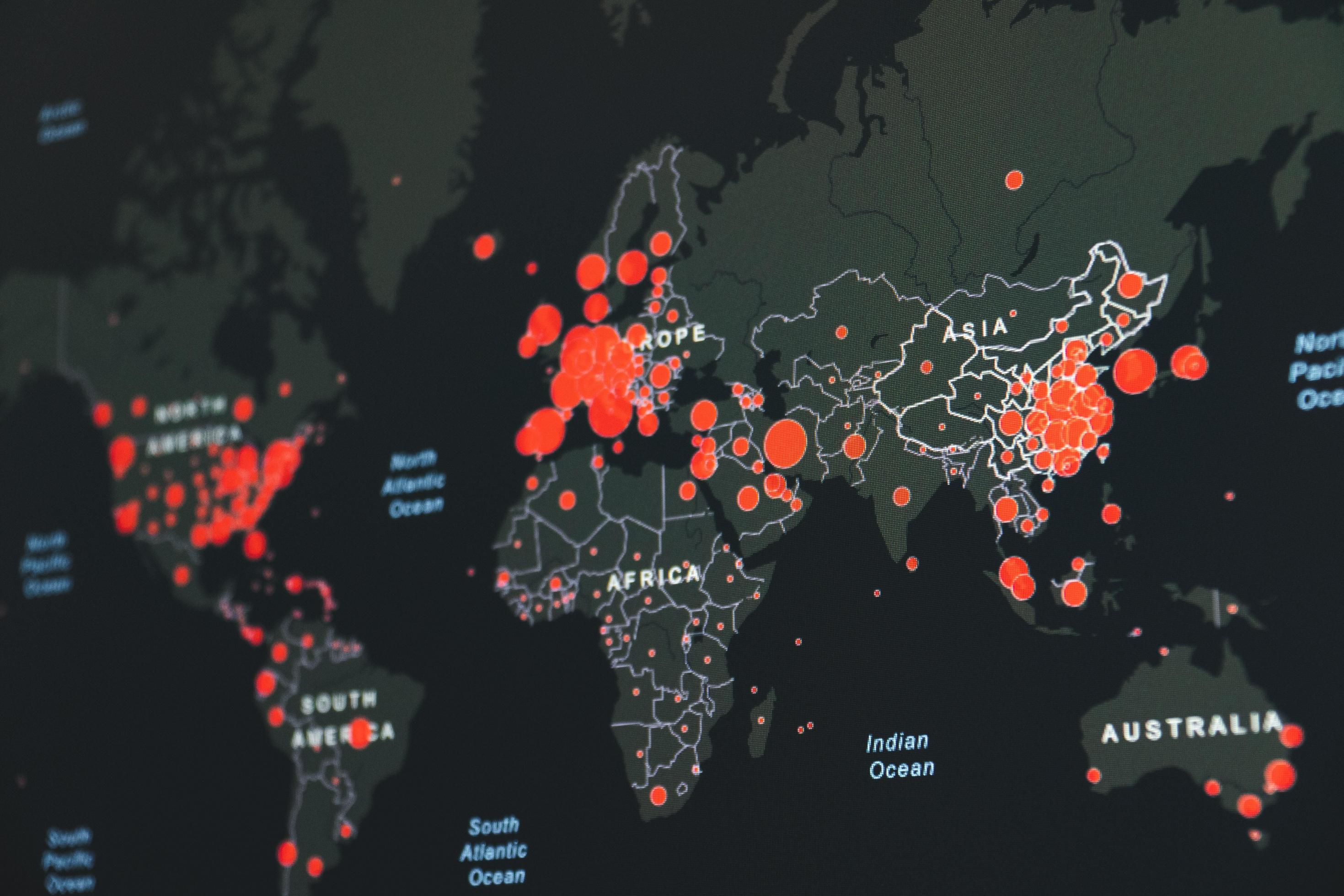 Auf der stilisierten Weltkarte wird mit unterschiedlich großen roten Punkten angezeigt, wo das Corona-Virus besonders stark verbreitet ist. In Afrika gibt es viele kleine Punkte. In den USA, in Europa und in China addieren sich die großen Punkte stellenweise zu roten Flächen.