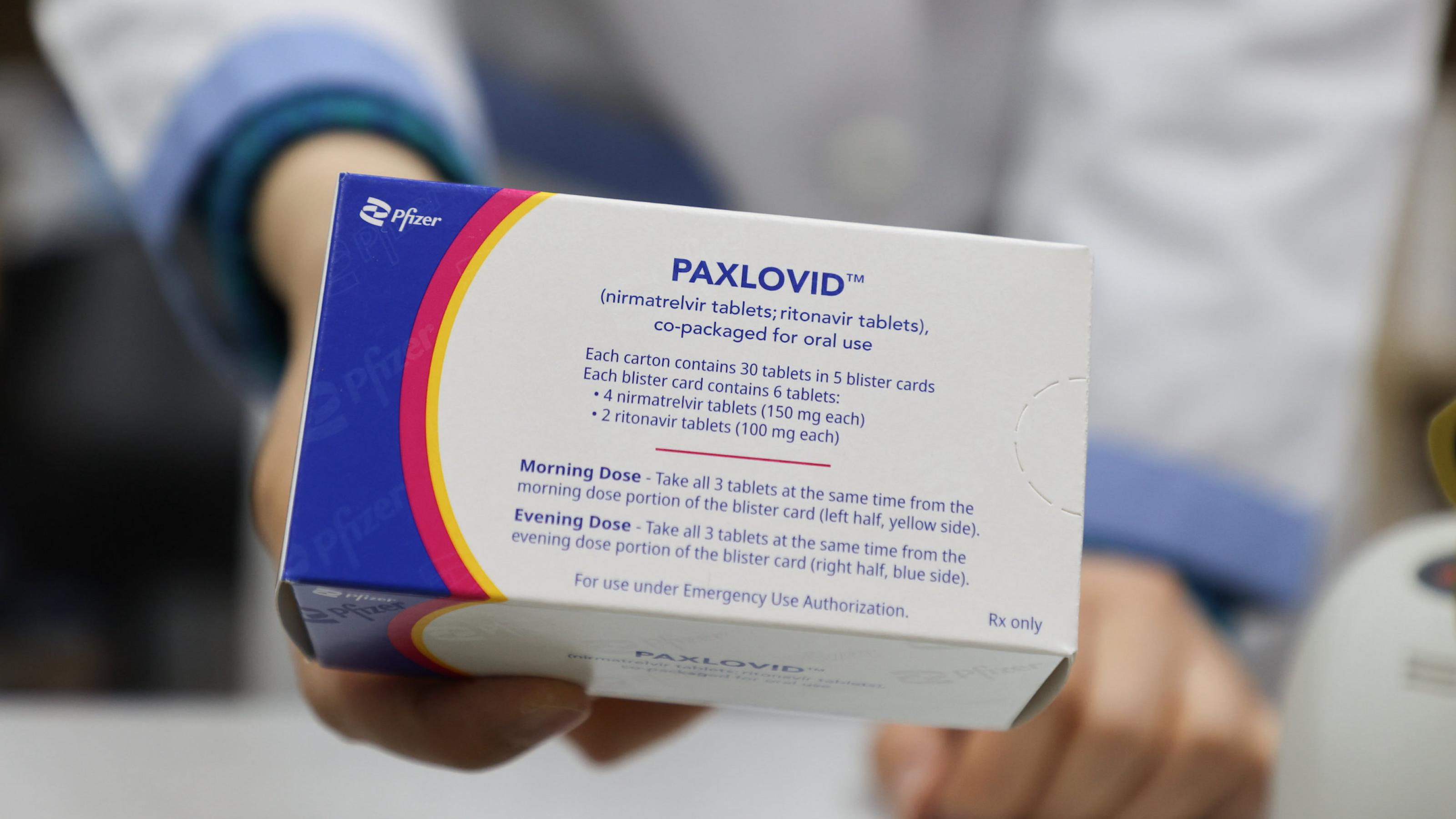 Ein Apotheker hält eine Packung Paxlovid in die Kamera.