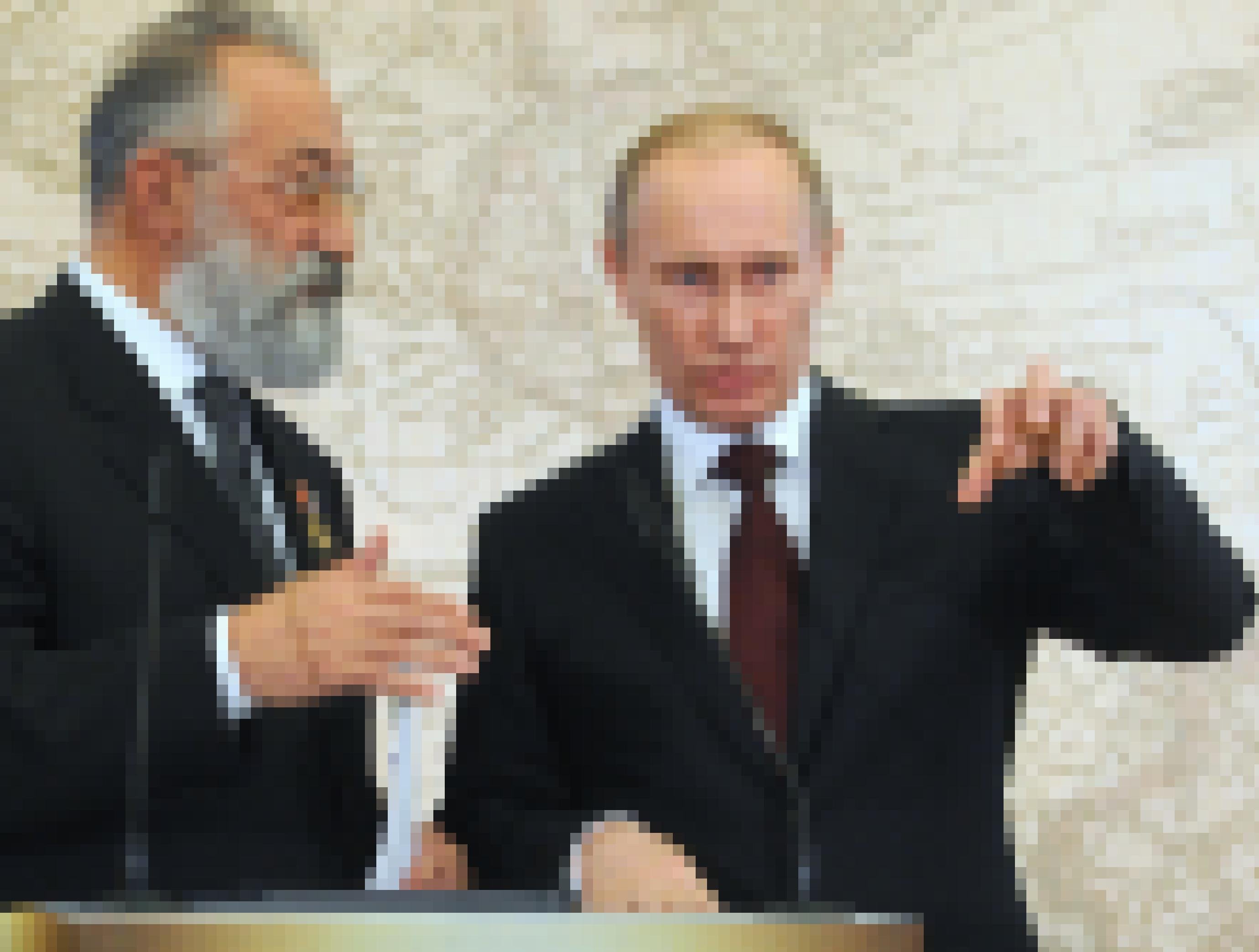 Der bärtige Forscher mit dem jung und schmal wirkenden Putin im Gespräch vor einer Weltkarte