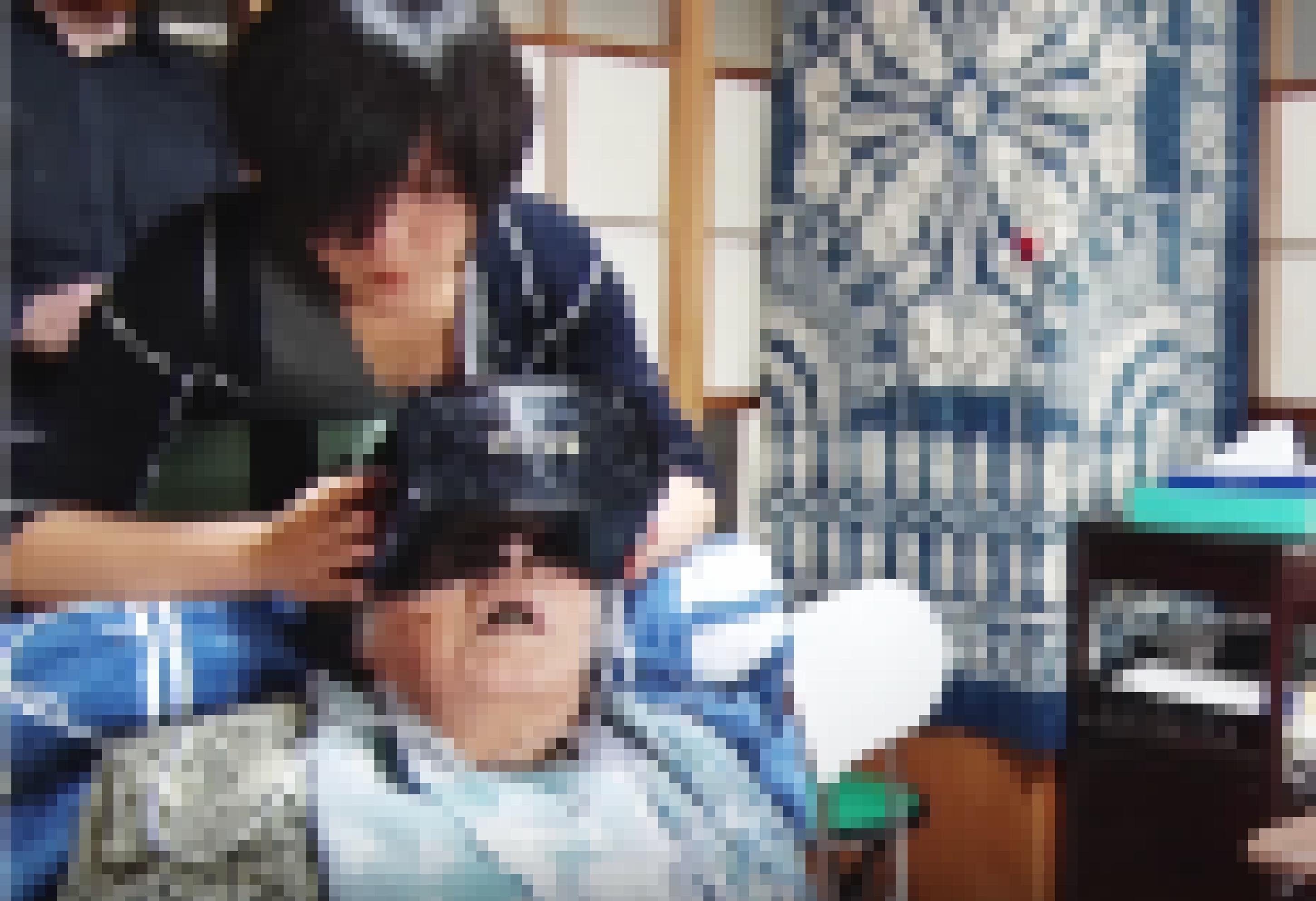 Eine alte Dame liegt halb aufgerichtet in ihrem Bett. Sie trägt eine große, klobige VR-Brille.