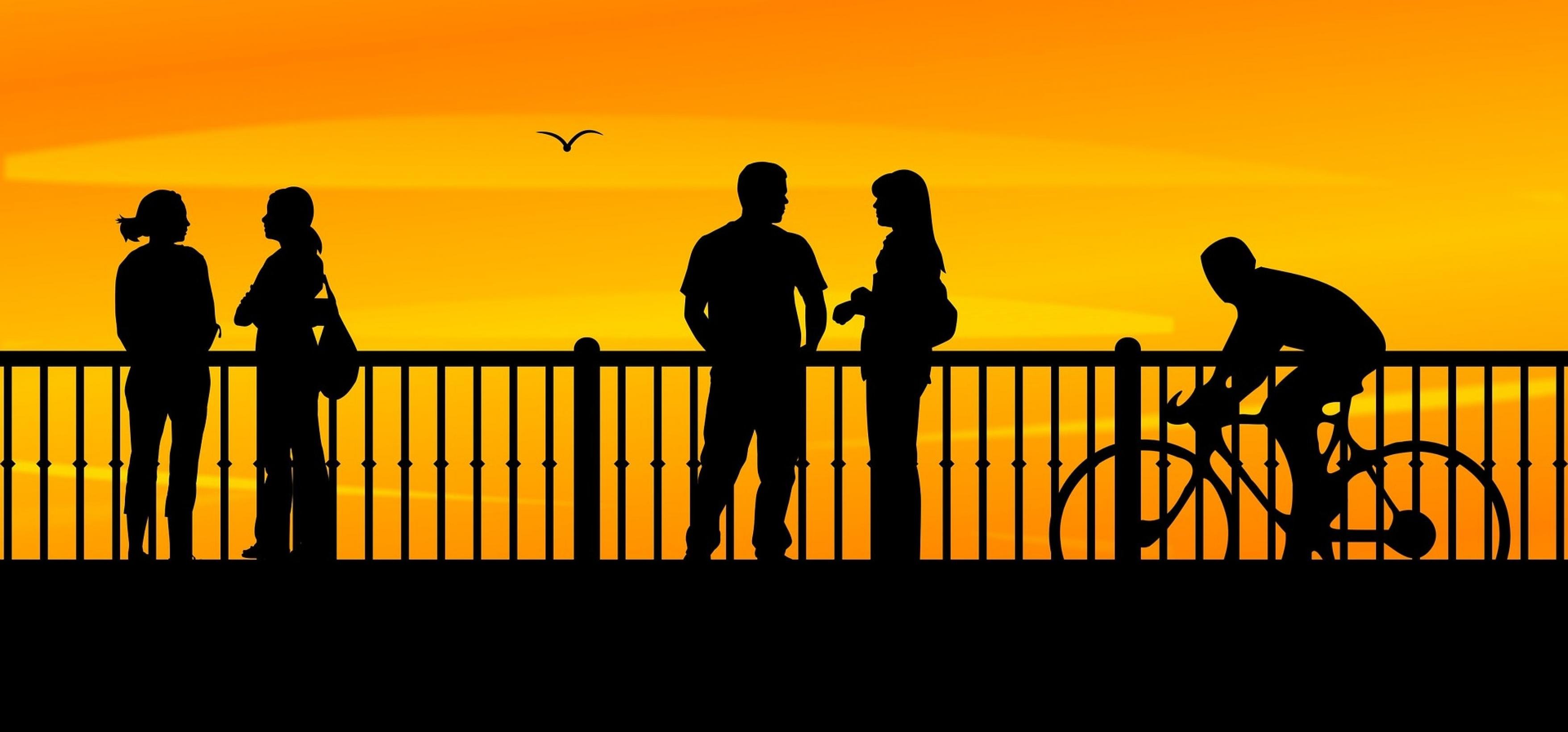 Menschen bei Sonnenuntergang auf einer Brücke.