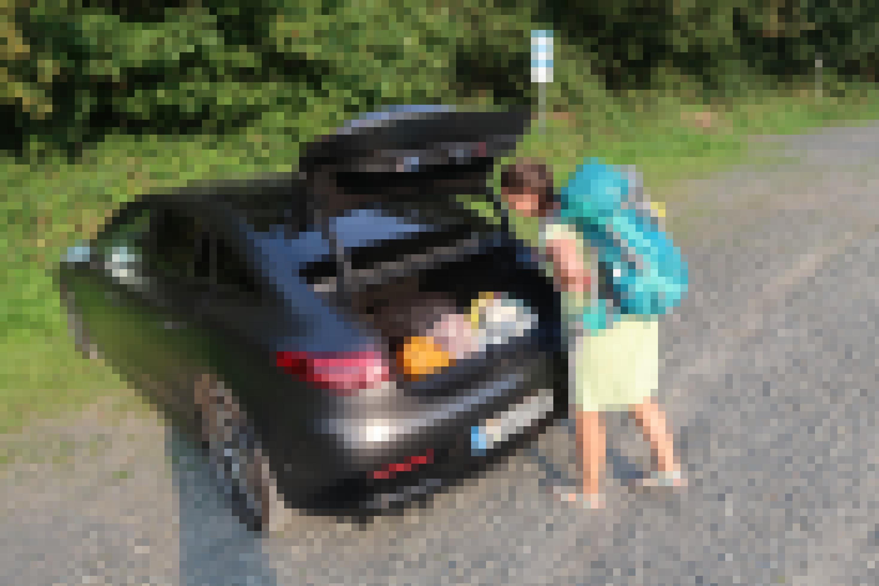 Eine Frau verfrachtet einen Rucksack in den Kofferraum des Mercedes EQE.