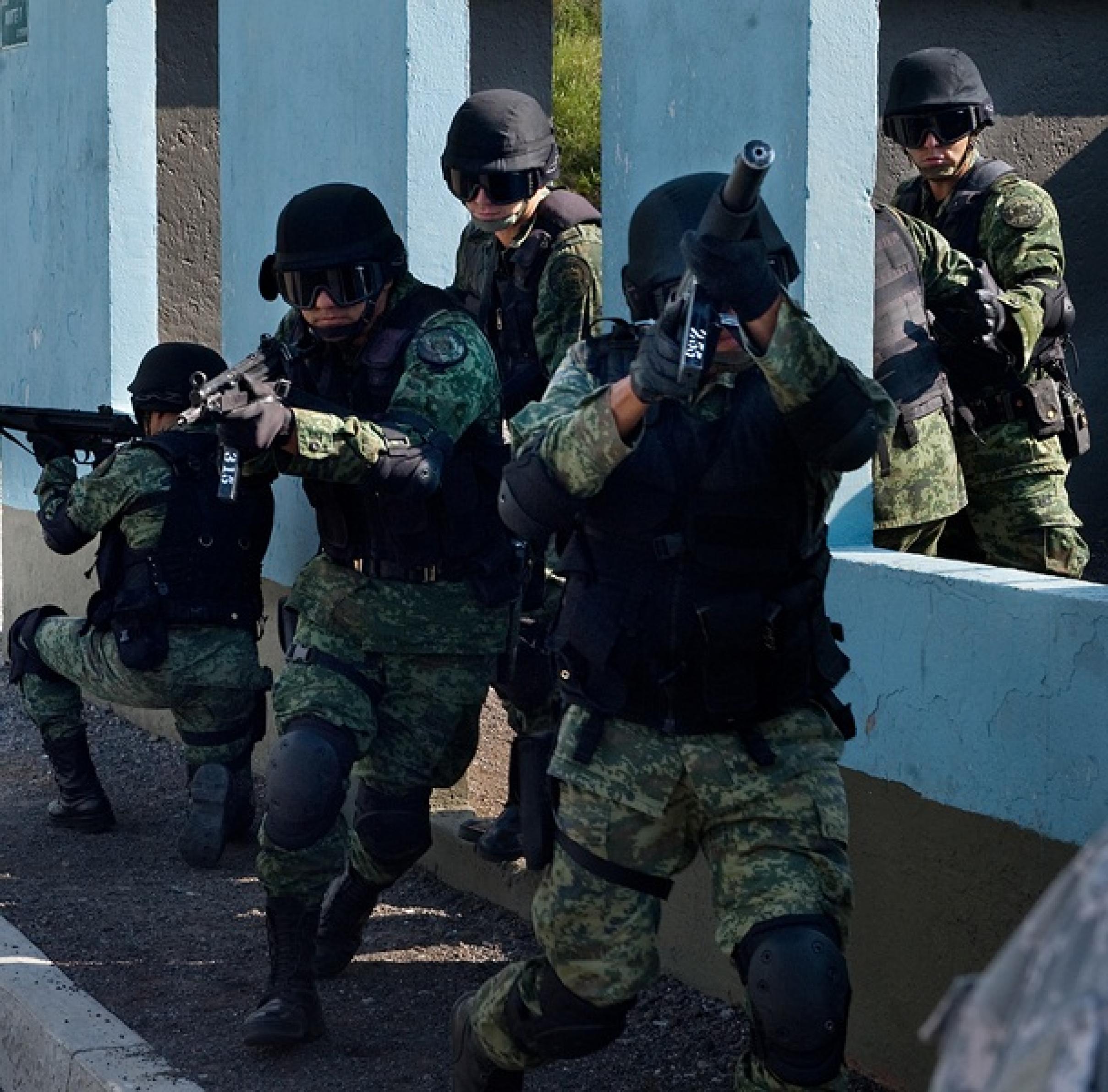 Bewaffnete Soldaten der mexikanischen Armee zielen nach vorne auf den Beobachter