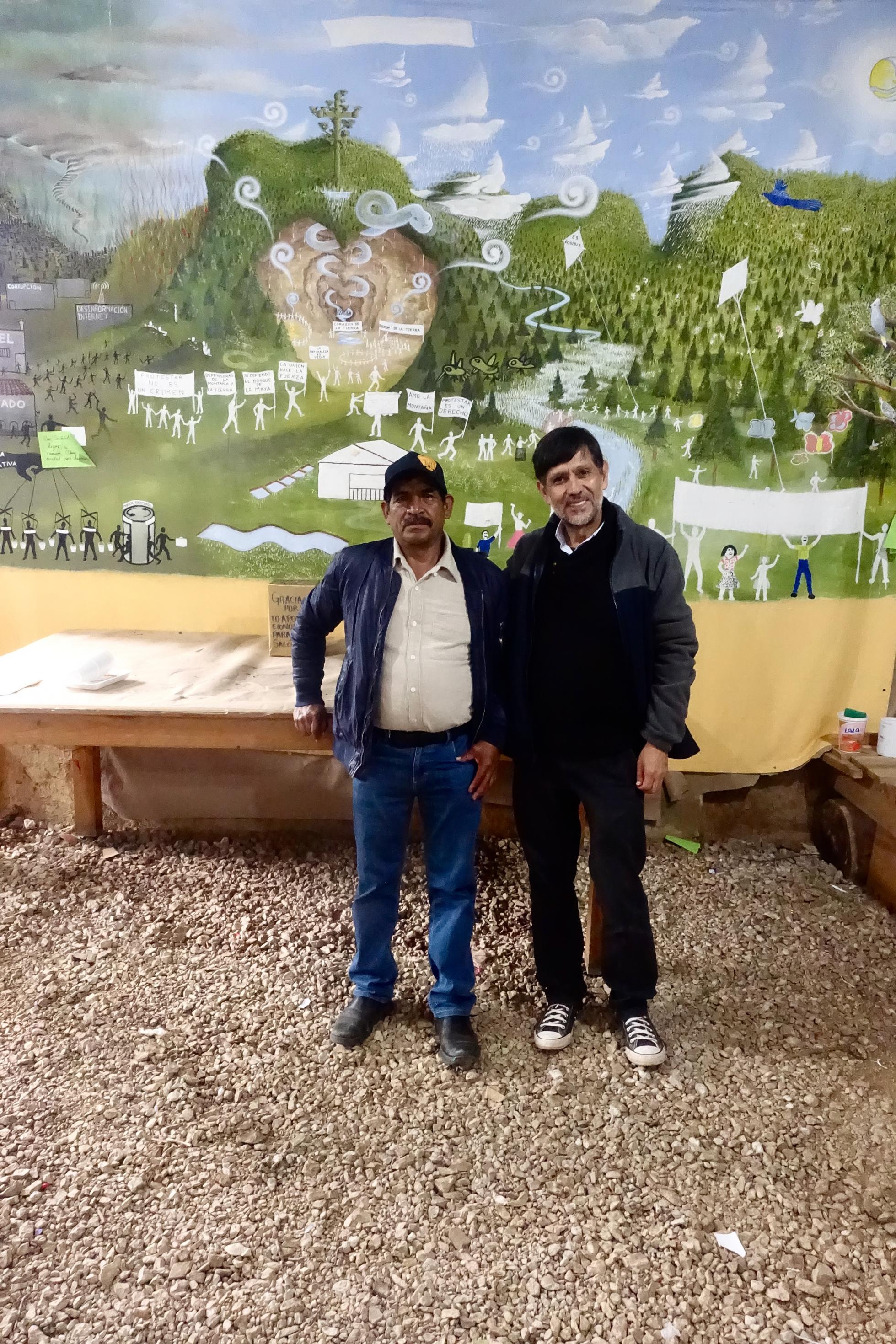 Zwei Männer stehen vor einem Wandbild in einem Stadtteilzentrum im südmexikanischen San Cristobal de las Casas.