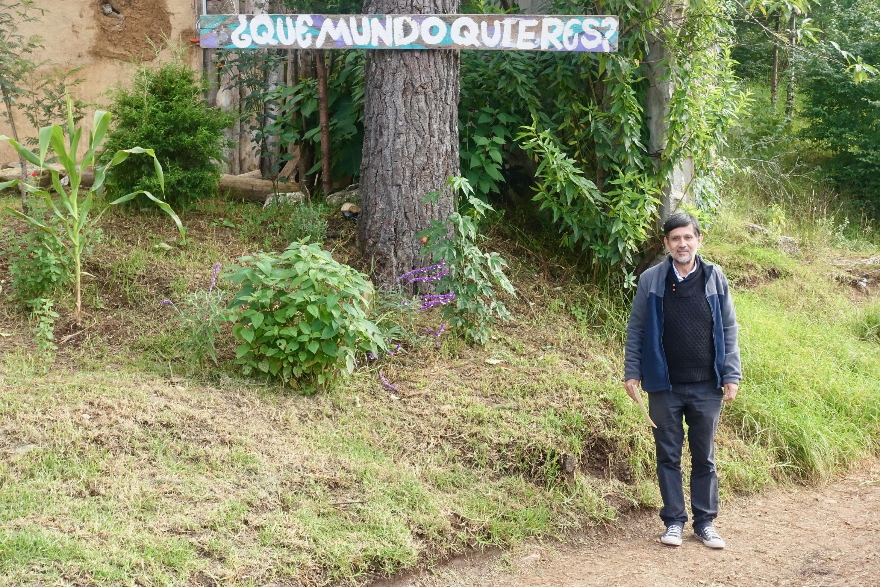 Umweltaktivist Martín López López steht vor einem Schild mit der Aufschrift: Qué mundo quieres? Welche Welt willst du?