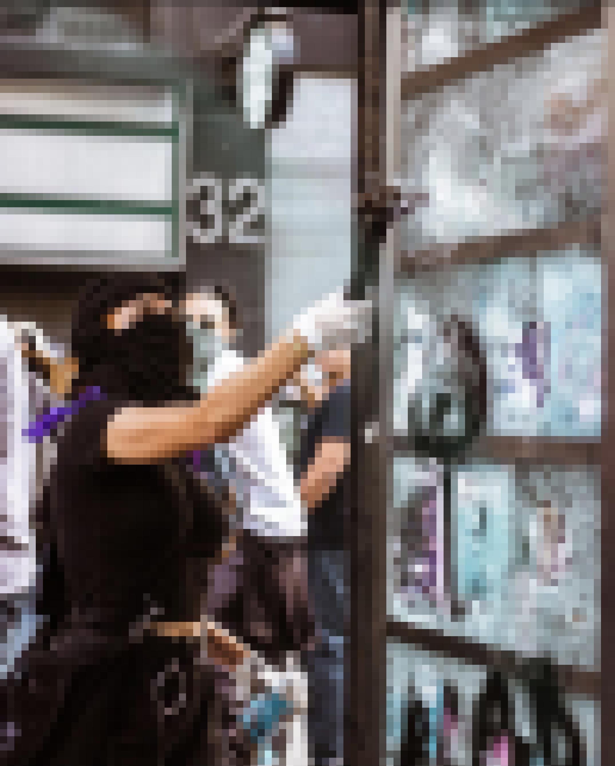 Eine vermummte mexikanische AKtivistin zerstört am Rande einer Frauendemonstration eine Werbeplakatwand.