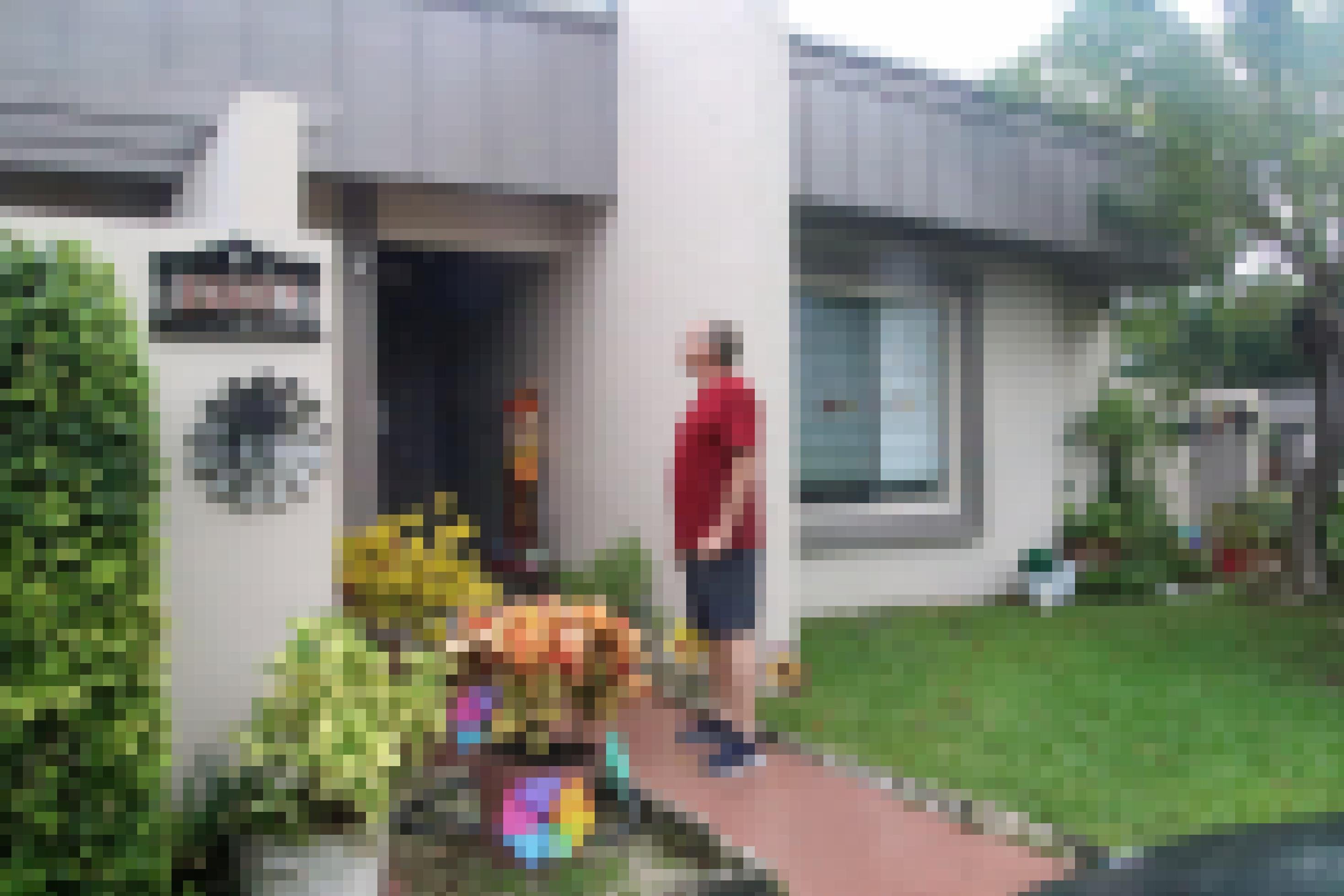 Ein Mann steht vor der Haustür eines Einfamilienhauses