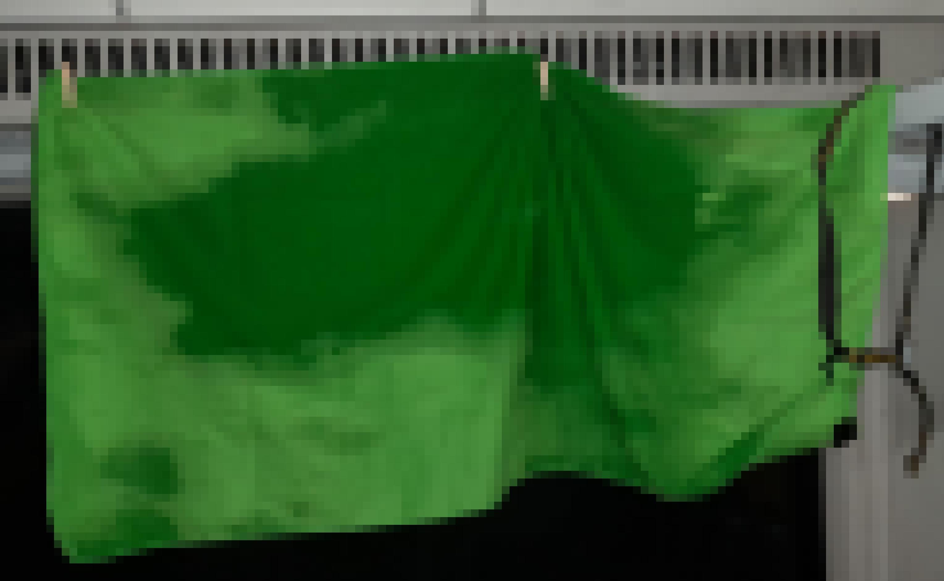 Unterhalb der das Abteilfenster krönenden Heizungsgitter hängt ein grünes Handtuch, das Wasserflecken aufweist.