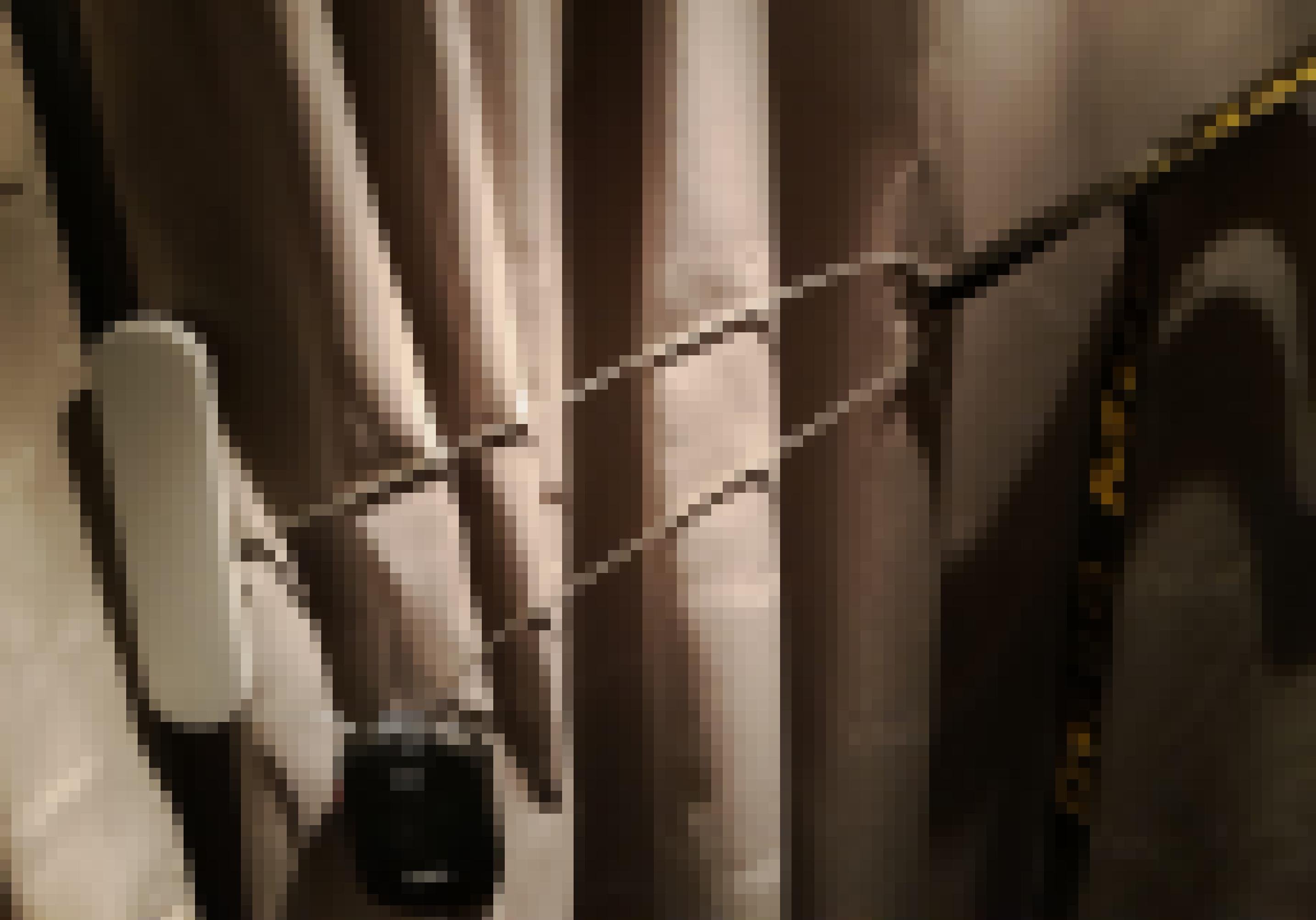 Vor dem bräunlichen, gewellten Vorhang mit der Aufschrift Nightjet ist ein Abus-Kabel-Fahrradschloss, verkettet mit einem Spannriemen, zu sehen, das den Türgriff umschlingt.