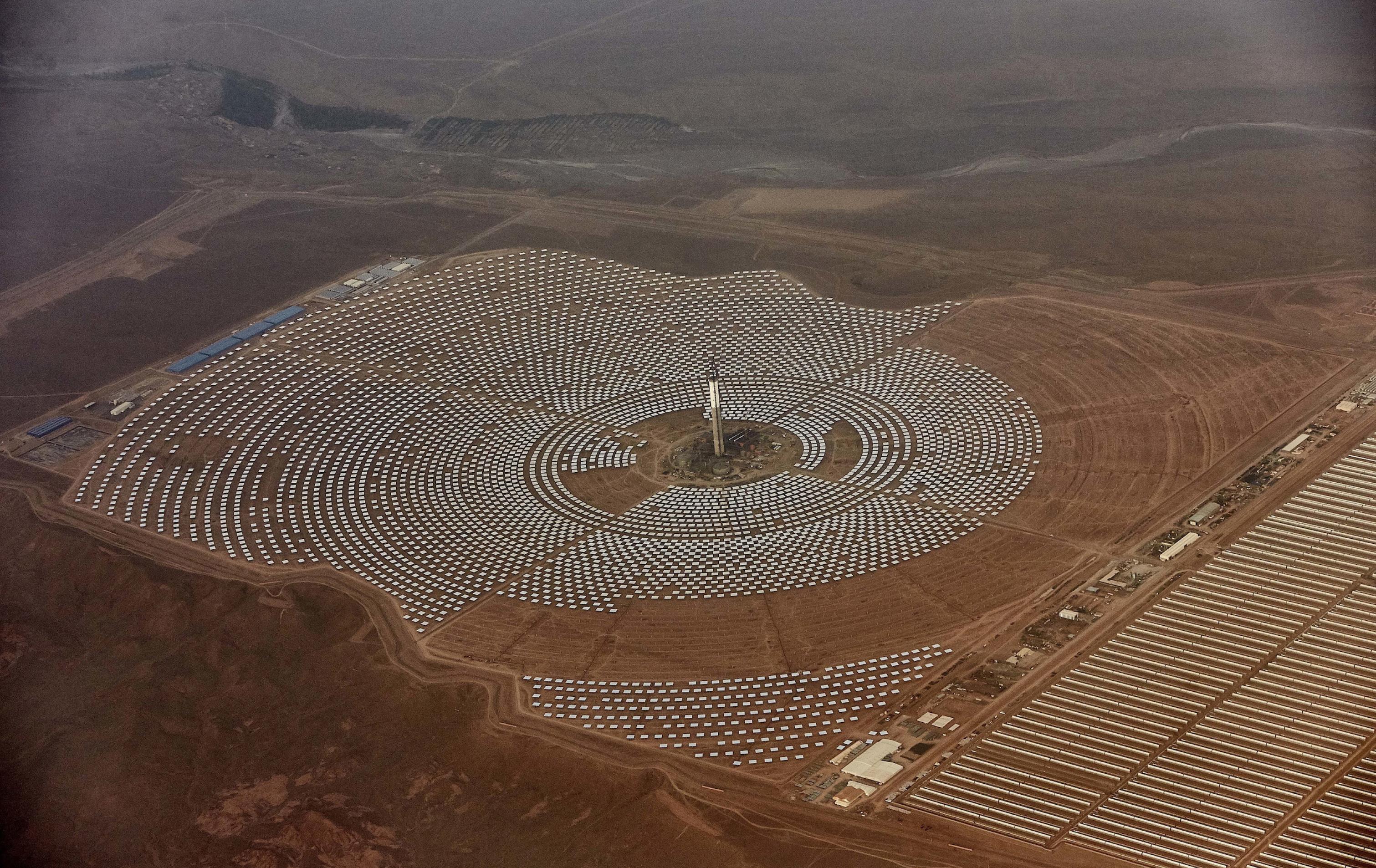 Große Anlage in der Wüste aus der Luft, in der Spiegel in zahlreichen Kreisen angeordnet sind.