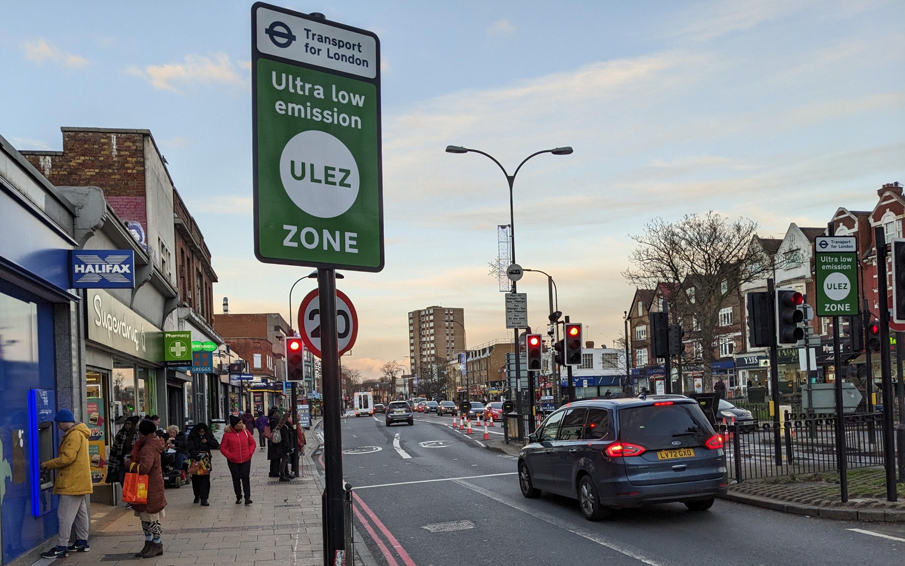 Eine Straßenszene in London, im Vordergrund ein Straßenschild mit der Aufschrift „ULEZ“