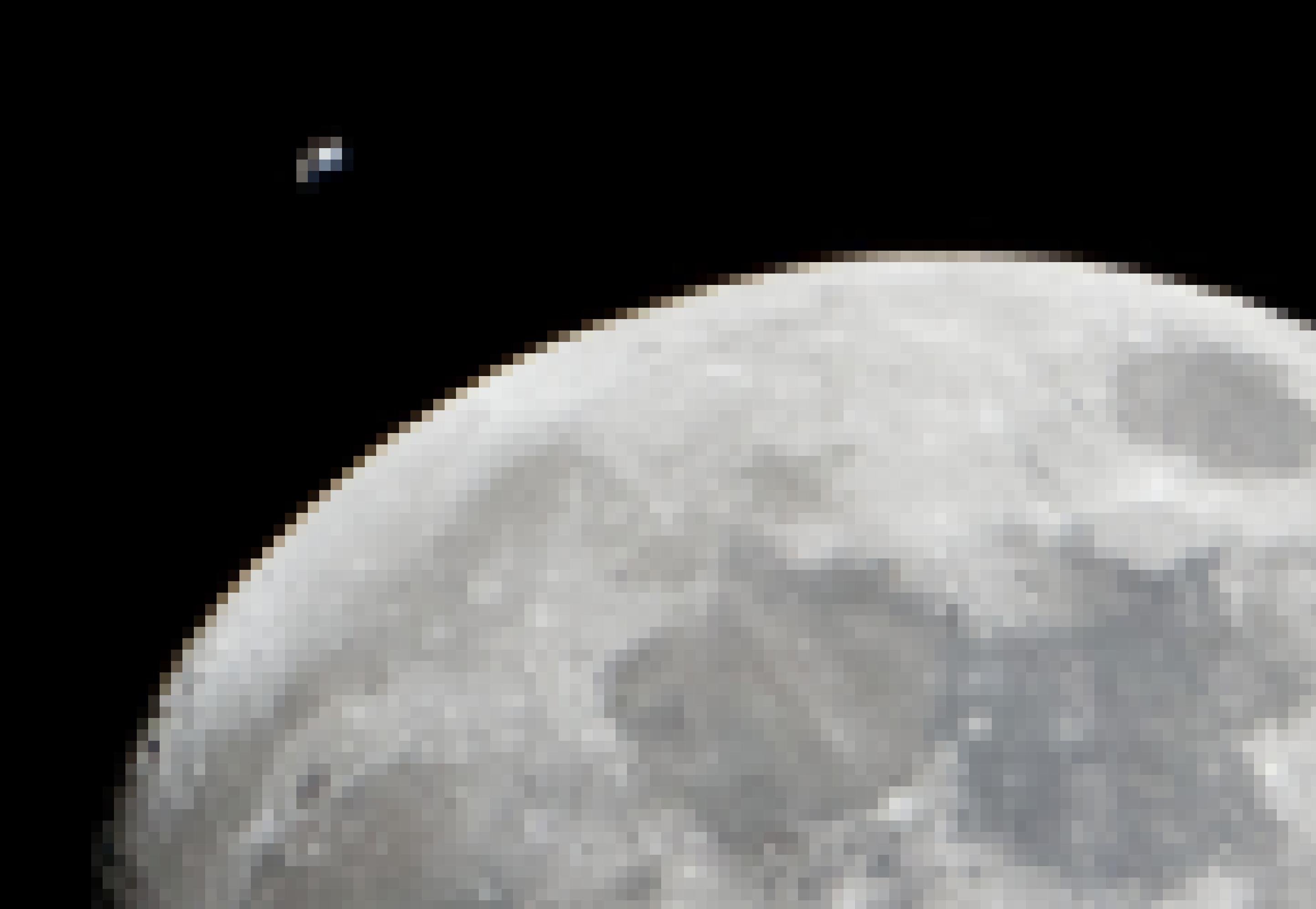 Eine große angeschnittene Mondscheibe, knapp daneben winzig klein die Internationale Raumstation, mit gerade so erkennbaren Solarzellen und Modulen. Das Bild wurde vom Erdboden aus aufgenommen – natürlich sind Station und Erdtrabant weit voneinander entfernt.