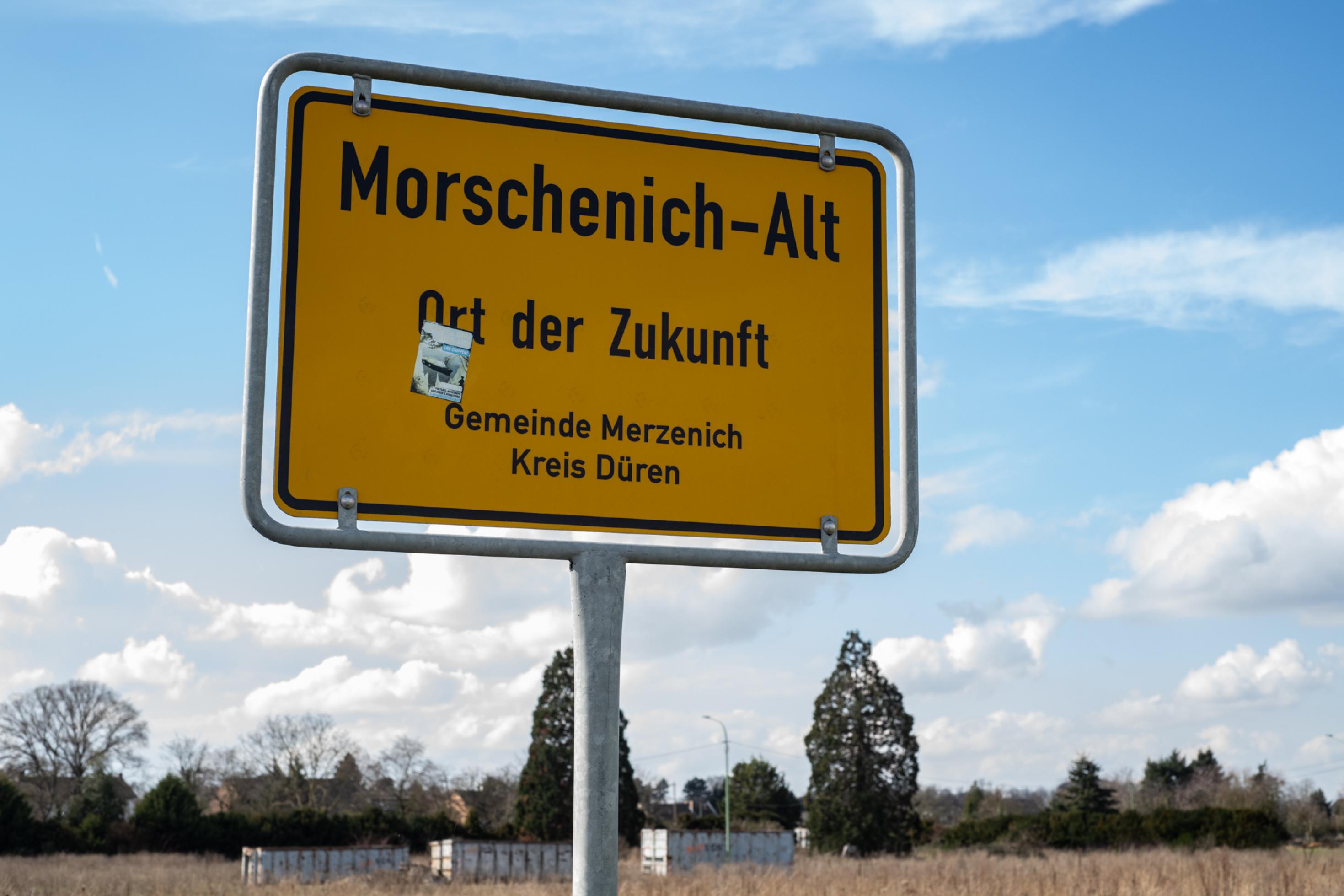 Gelbes Ortseingangsschild mit der Aufschrift Morschenich-Alt – Ort der Zukunft