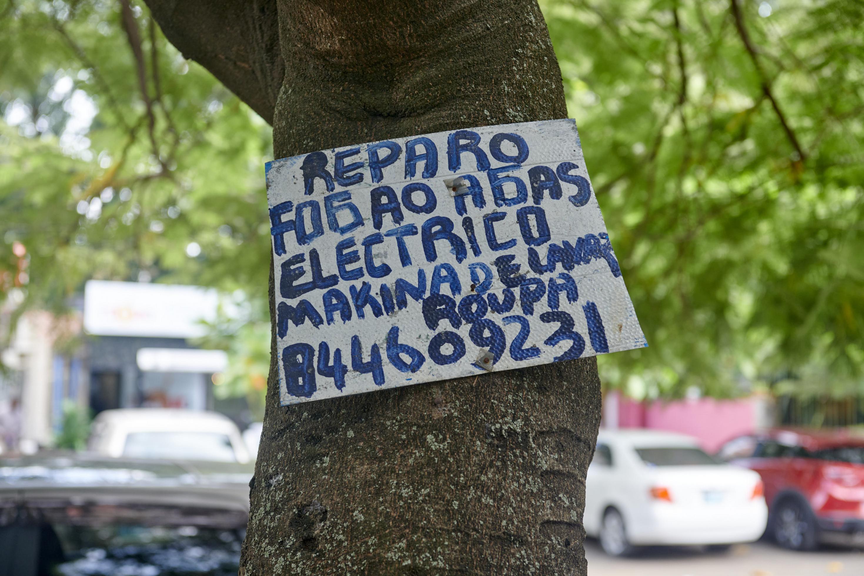 Ein selbstgemaltes Bild an einem Baum, mit der Telefonnummer eines Elektrikers