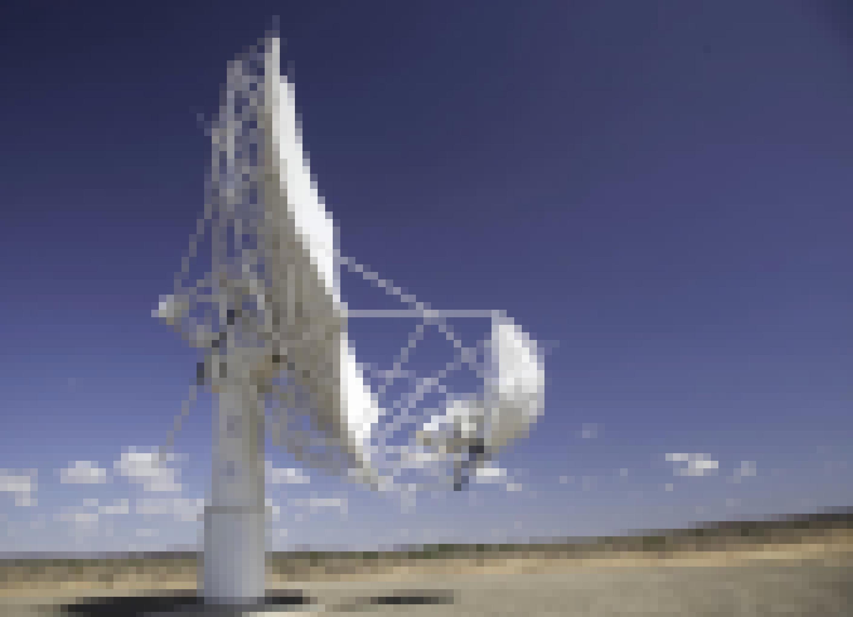 Die Parabolantenne eines Radioteleskops steht in einer Wüstenlandschaft.