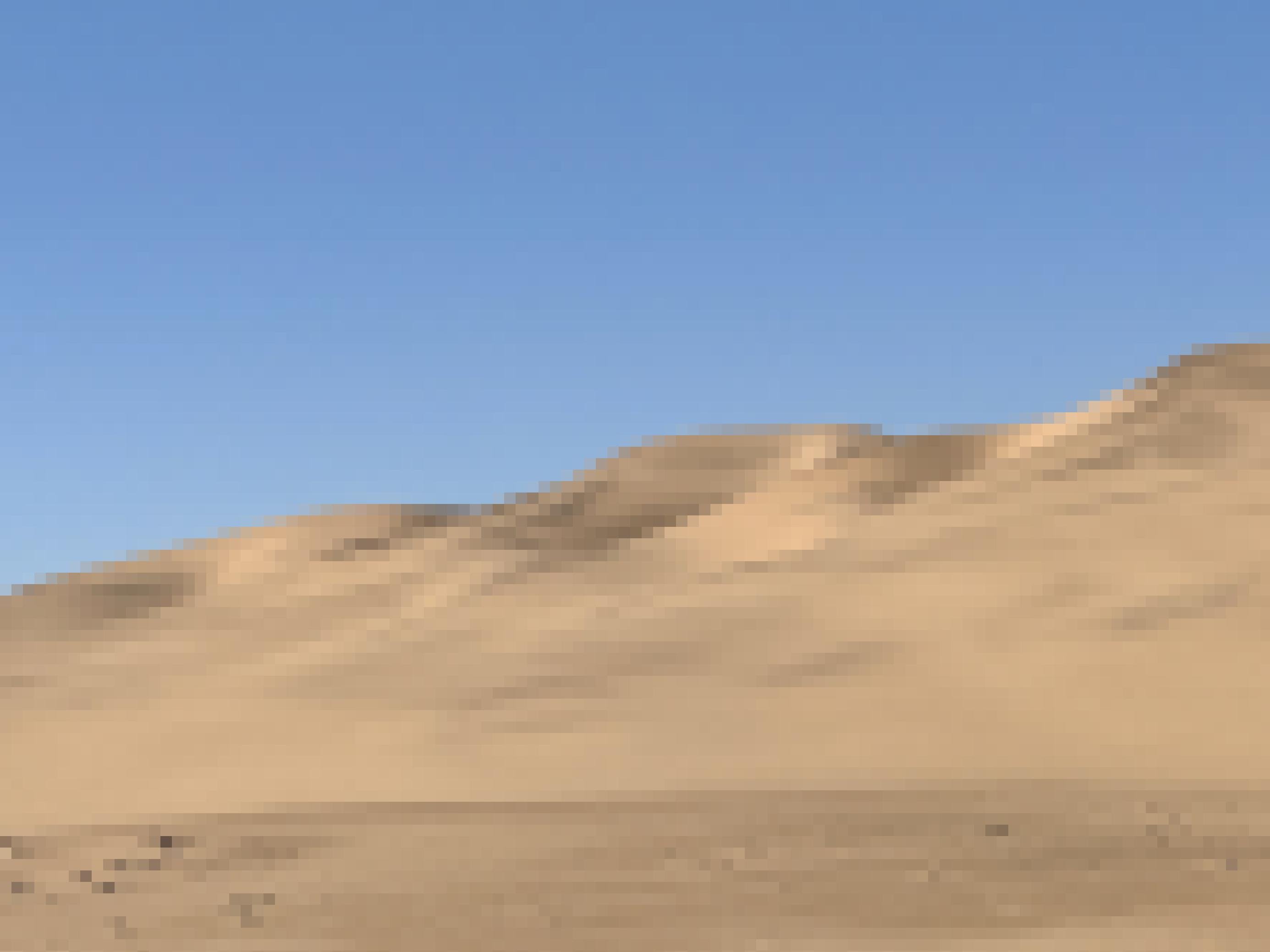 Eine Sanddüne in der Nachmittagssonne vor blauem Himmel