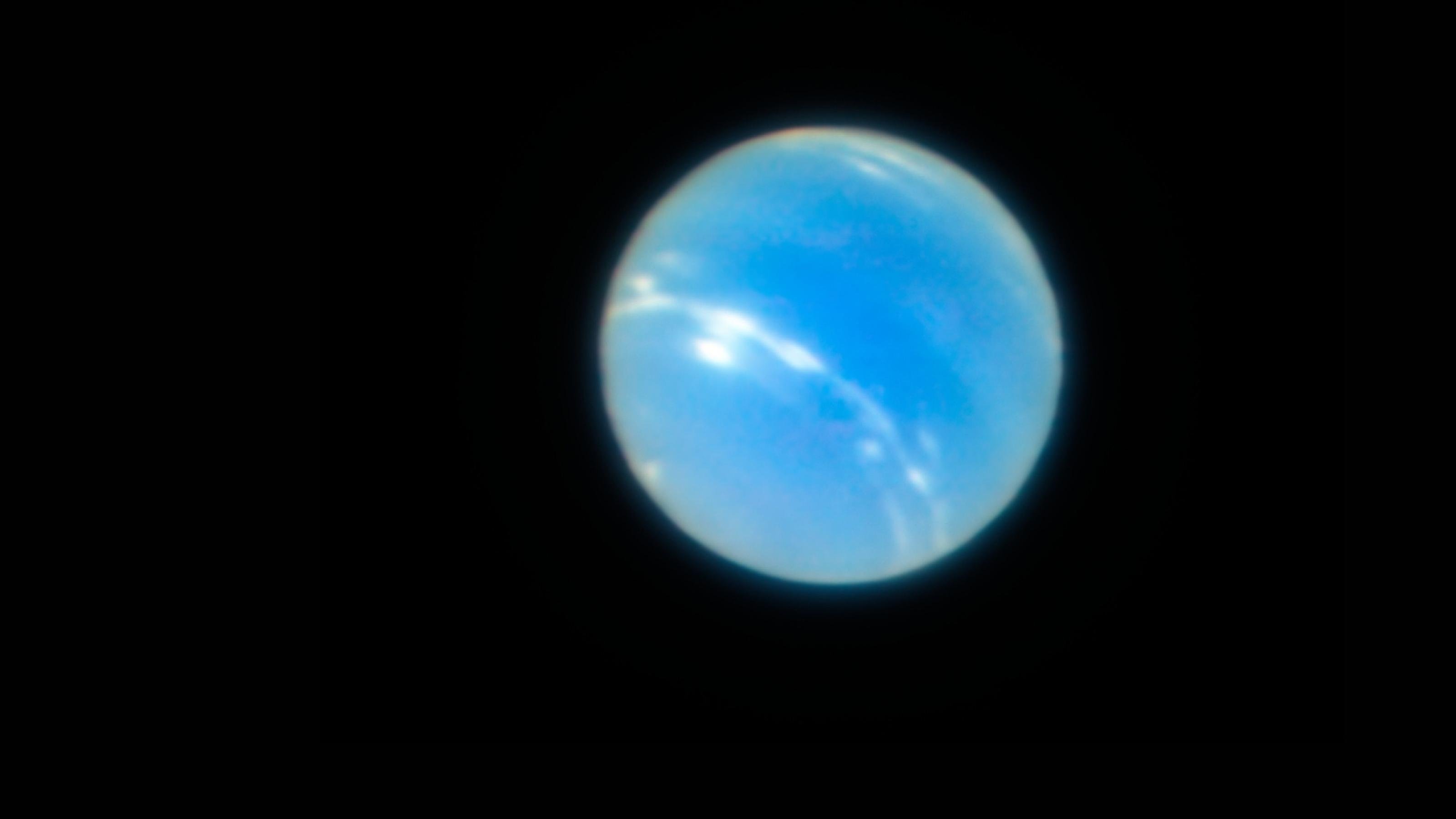 Gestochen scharfe Aufnahme des Neptuns, auf der auch weiße Wolkenbänder sichtbar sind