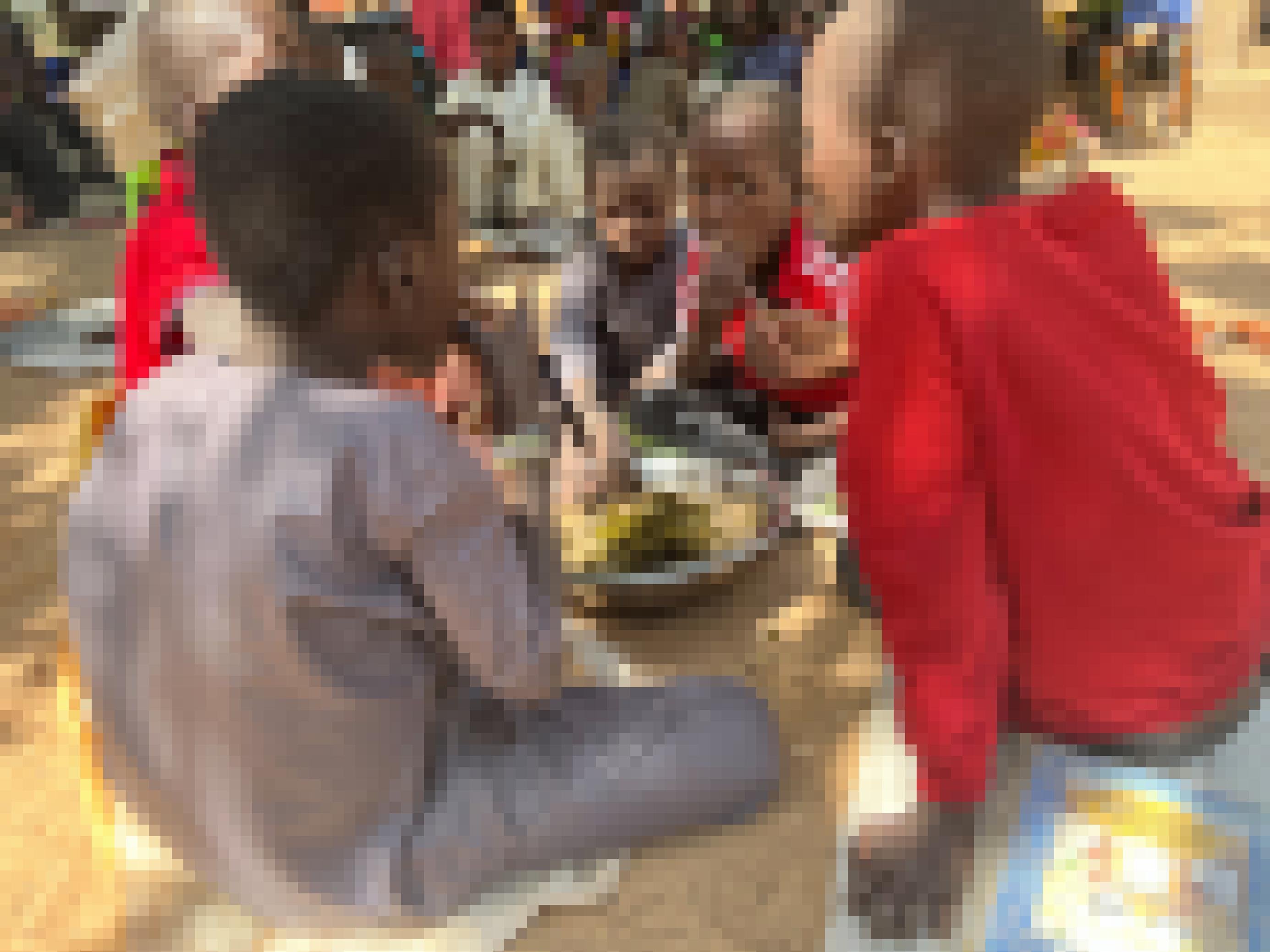 Kleine Jungen sitzen rund um eine Schüssel mit Hirsebrei auf dem Boden und Essen.