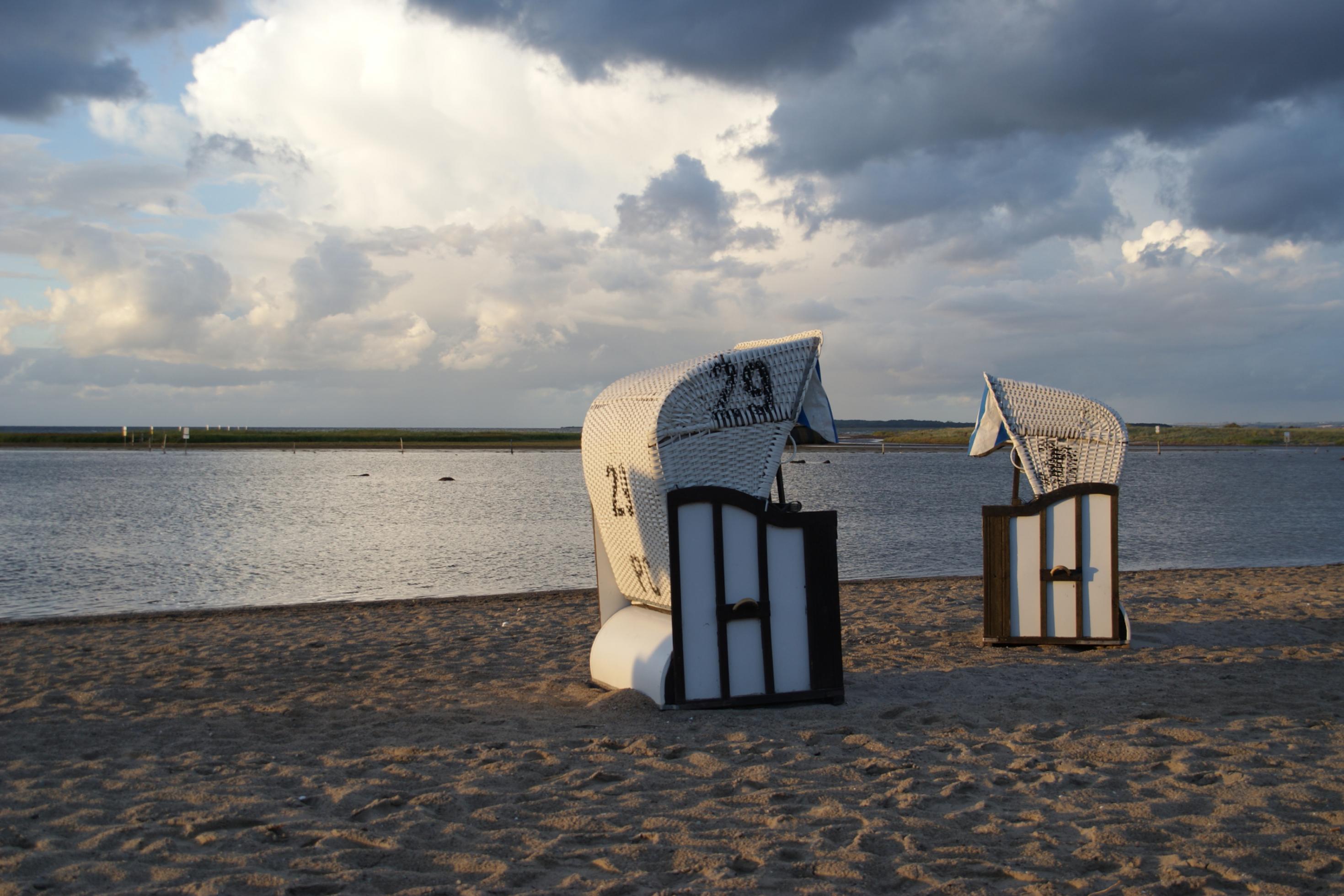 Zwei Strandkörbe, weißer Sand, blaues Meer