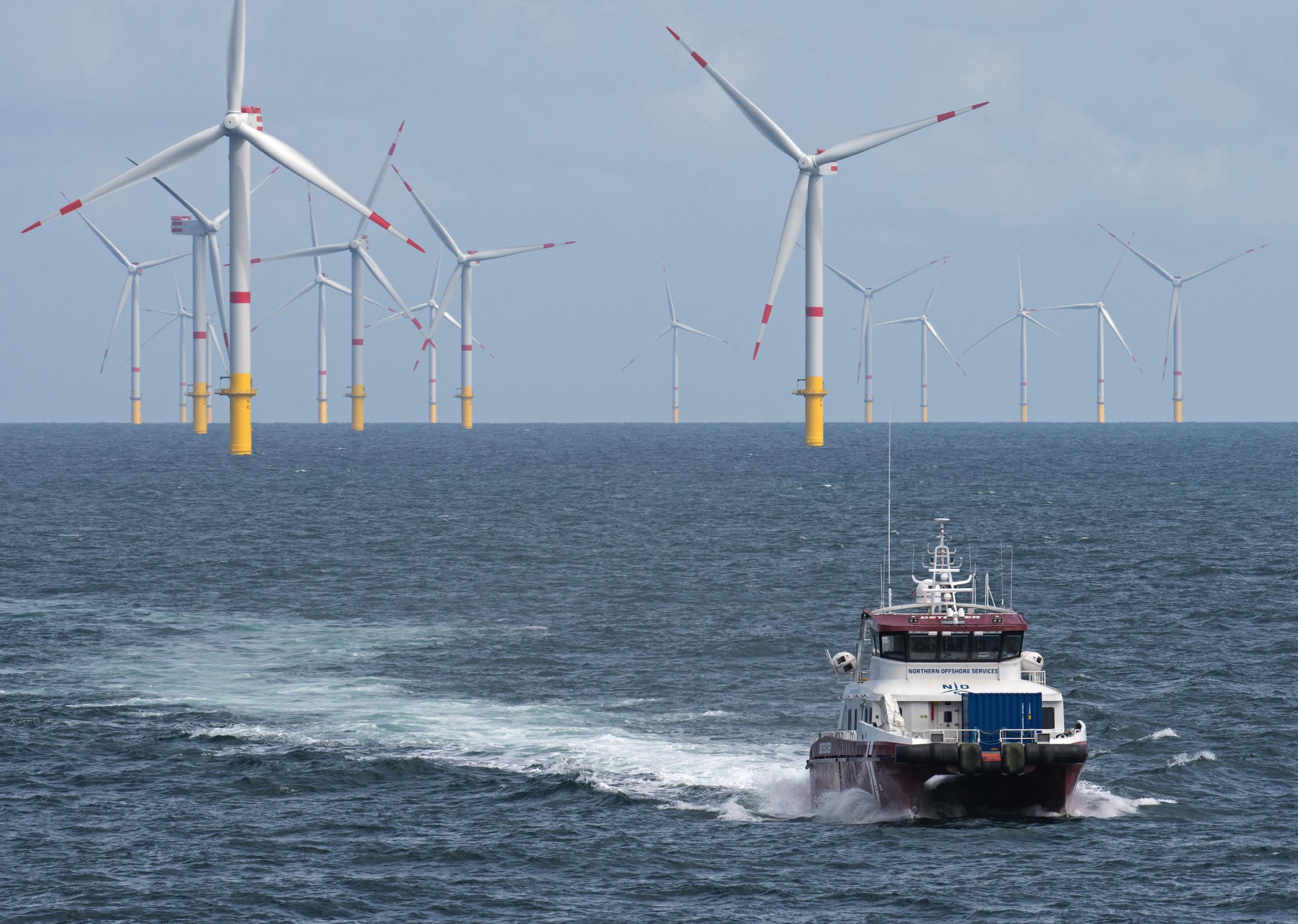 Windkraftanlagen im Meer, im Vordergrund ein Serviceboot.