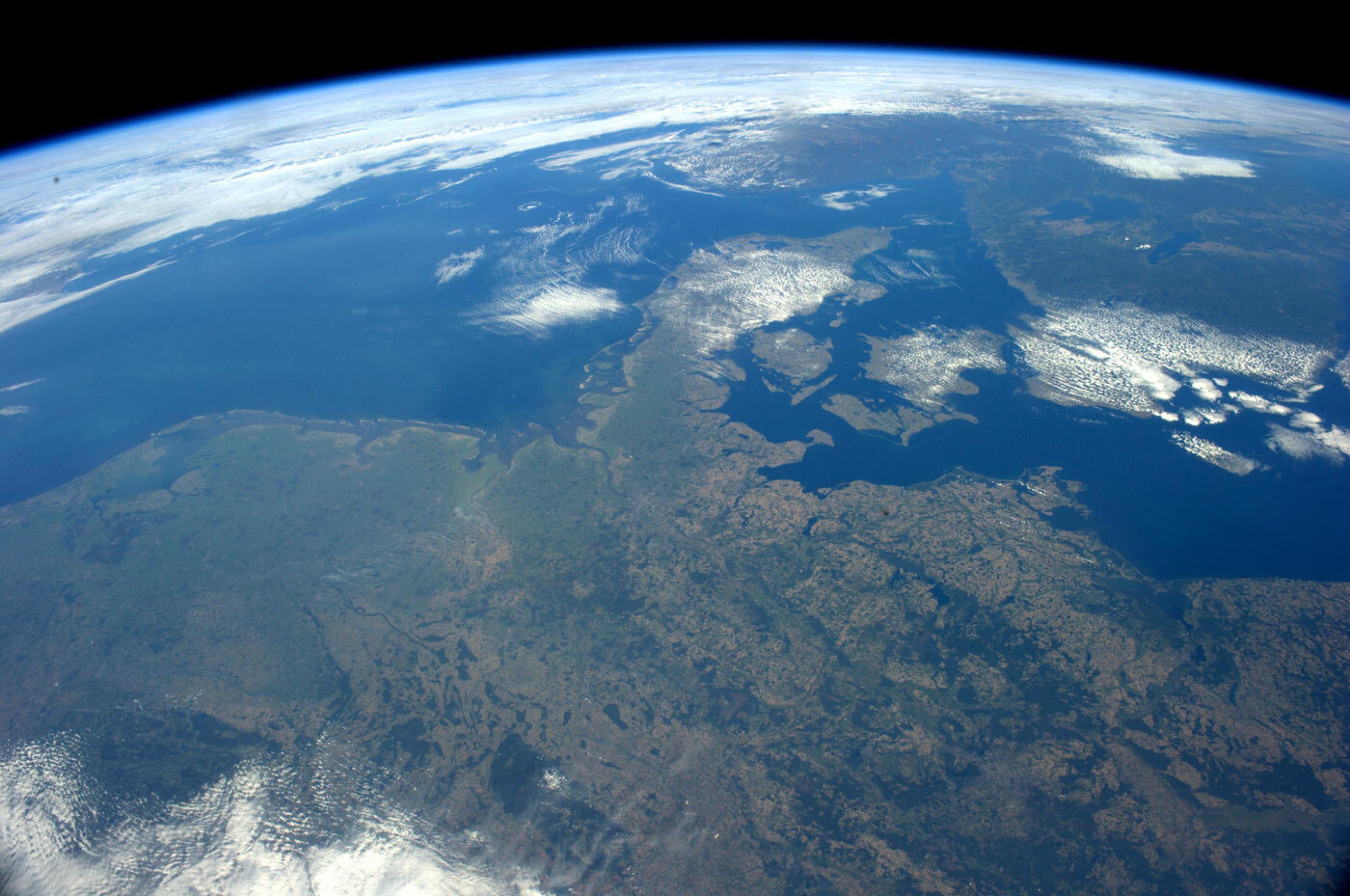 Dieses Foto zeigt Nordeuropa – und die dünne, zerbrechlich wirkende Atmosphäre, die Ulf Merbold beschreibt. Gut zu sehen ist auf dieser Aufnahme auch der zerbrechliche Nationalpark Wattenmeer, von den Westfriesischen Inseln über die Kette der Ostfriesischen Inseln bis Nordfriesland und Dänemark.