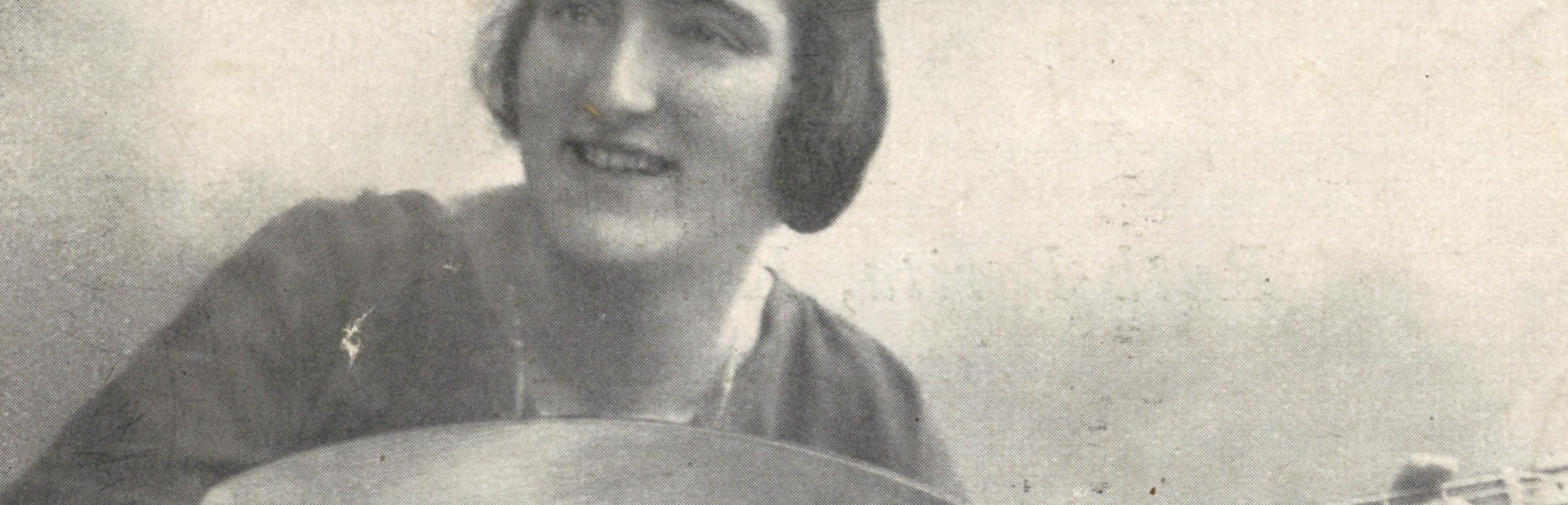 Foto: Brustbild einer jungen Frau mit dunklem Haar, die eine Laute spielt.