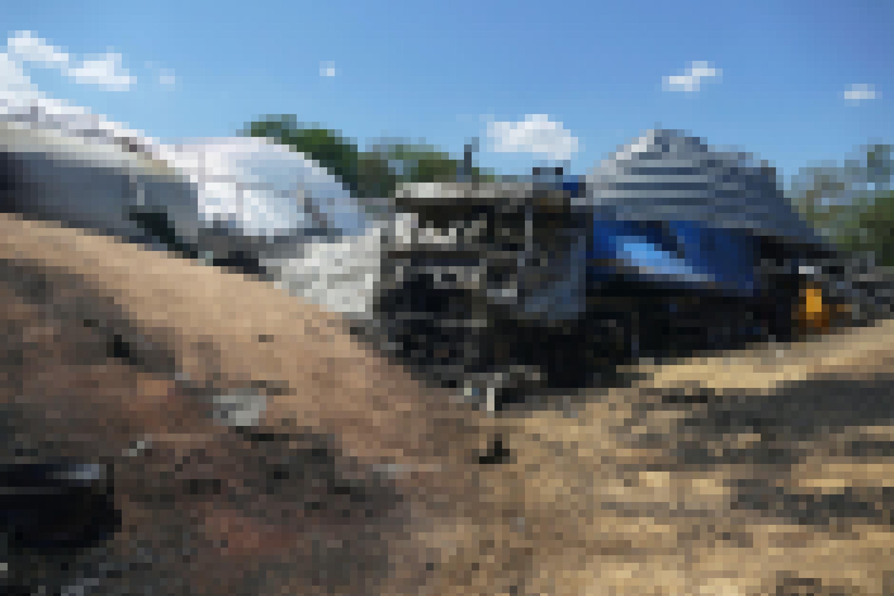 Eine Halbtotale zeigt die Zerstörung nach einem russischen Angriff auf ein Getreidelager: Getreide liegt offen herum. Ein verbrannter blauer Lastwagen steht neben einem beschädigten Getreideterminal eines Agrarunternehmens in der Region Odessa, Südukraine. Das Foto ist vom 21. Juli 2023.