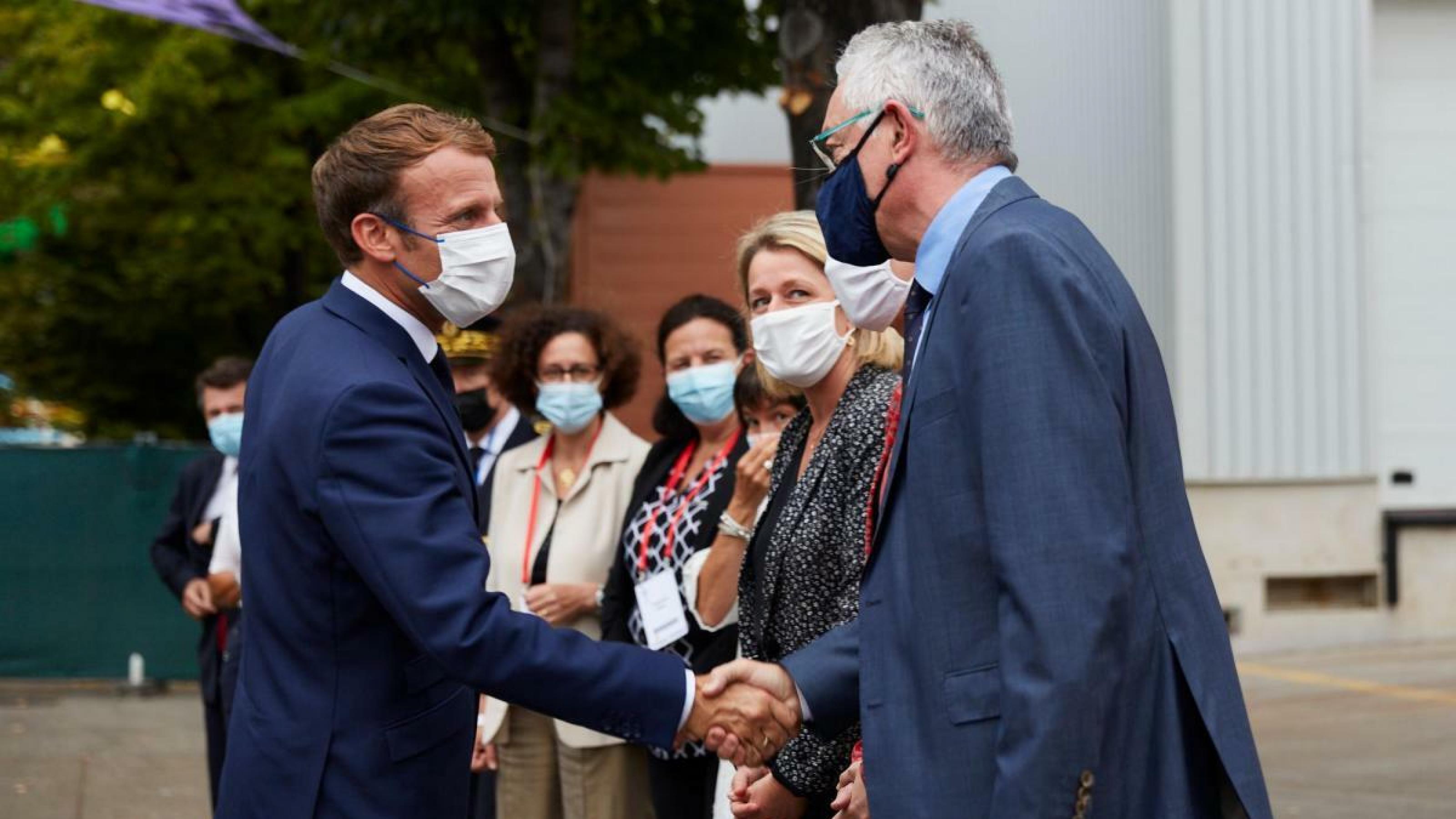Emmanuel Macron schüttelt die Hand des IUCN-Direktors Bruno Oberle auf dem Kongressgelände.