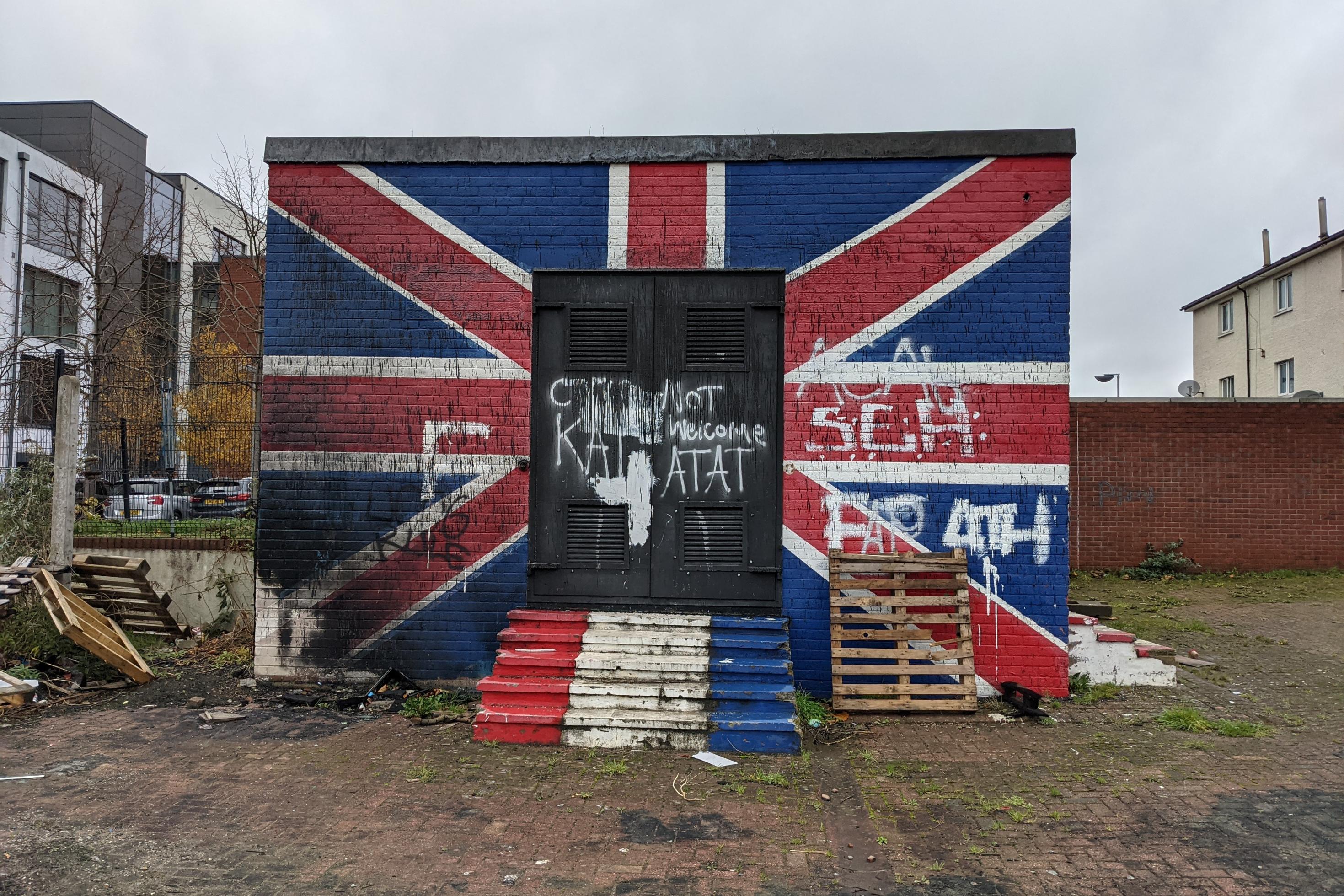 Ein Gebäude ist mit einer britischen Flagge bemalt und sieht verwahrlost aus.