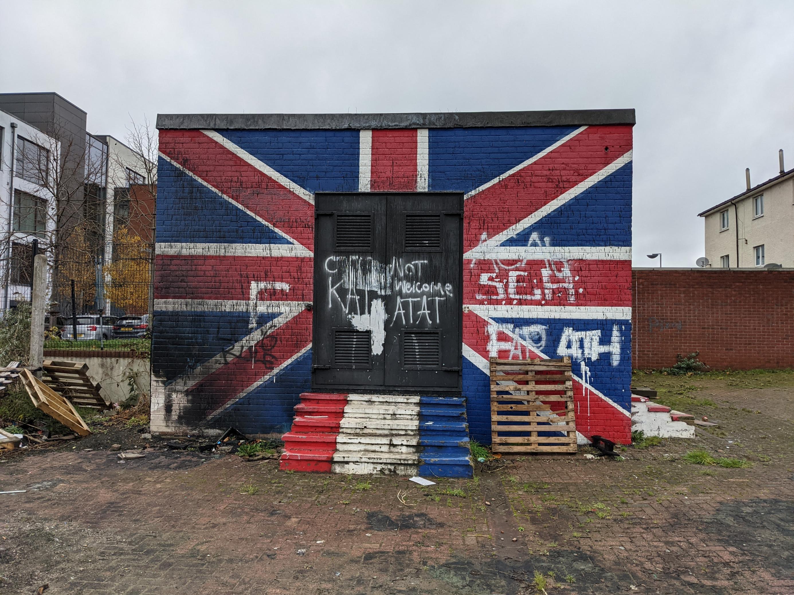 Ein Gebäude ist mit einer britischen Flagge bemalt und sieht verwahrlost aus.