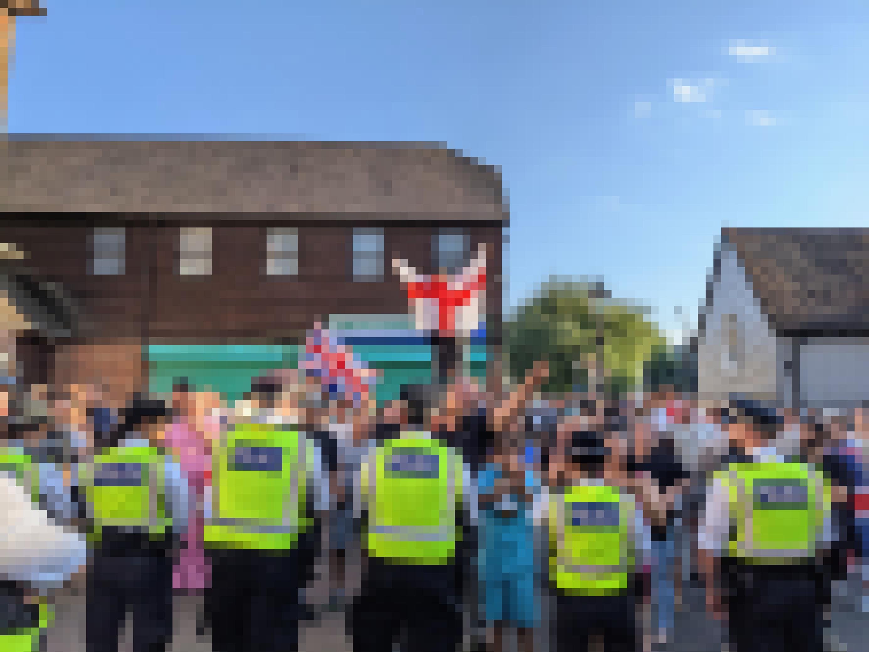 Hinter einer Reihe von Polizisten stehen Protestierende mit England-Flaggen.