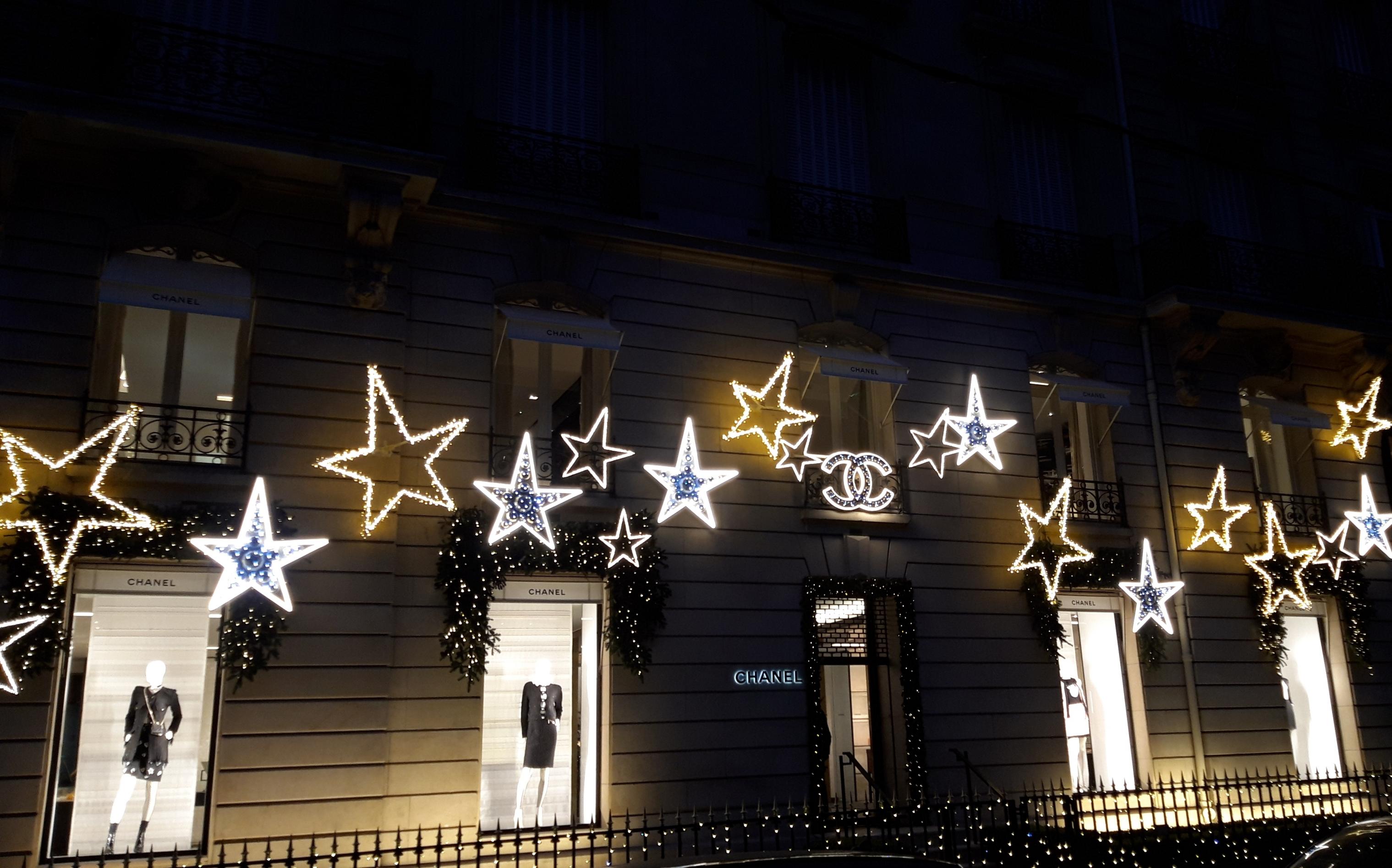 Übervoller weihnachtlicher Lichterglanz an der nächtlichen Chanel-Fassade.