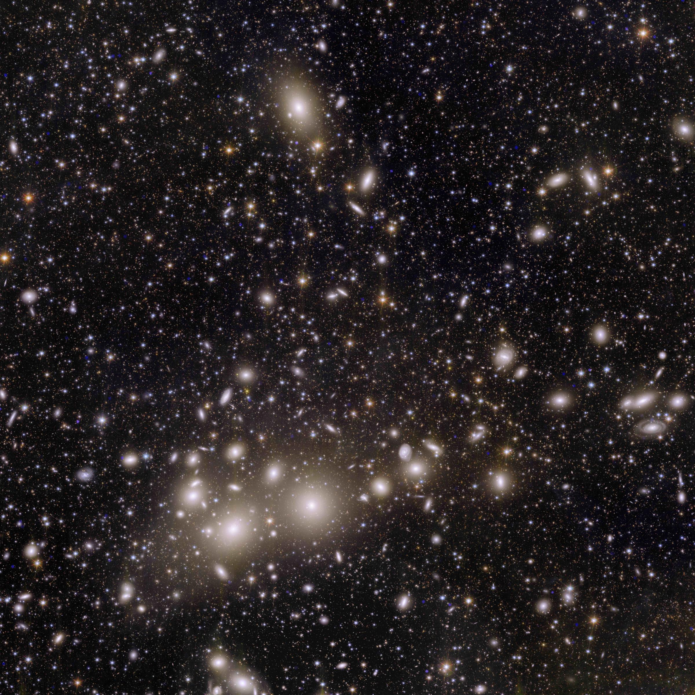 Ein Haufen heller Galaxien vor dunklem Hintergrund.