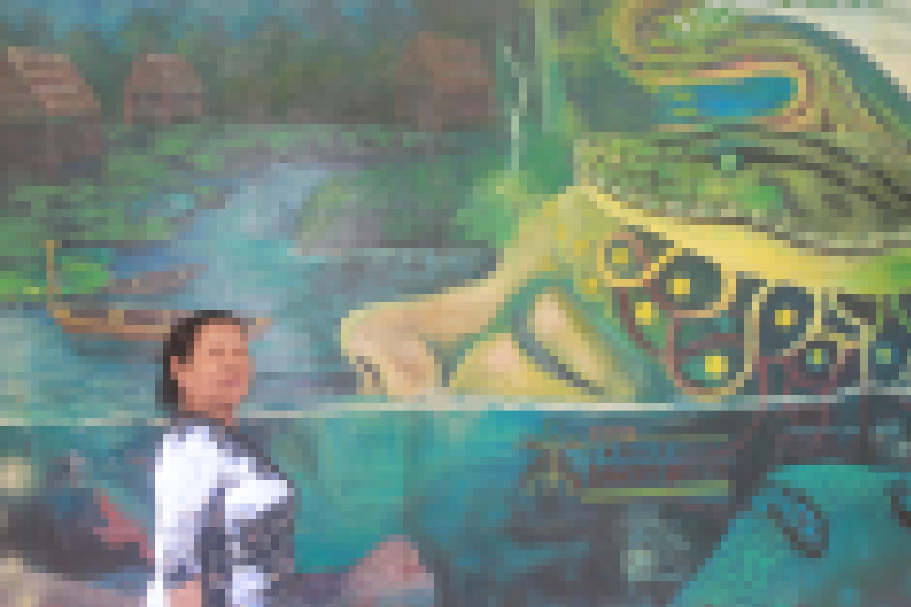 Ein buntes Wandgemälde zeigt eine halb im Wasser liegende Frau, auf deren Kopf sich eine Boa ringelt. Links am Bildrand betrachtet eine alte Frau das Bild.