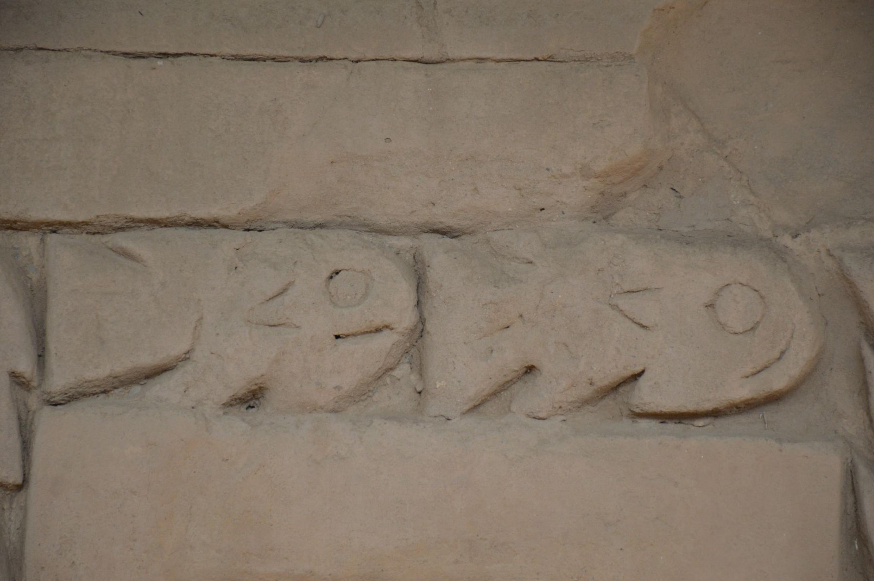 Beiger Sandstein, darauf ein Relief mit zwei Fischen.